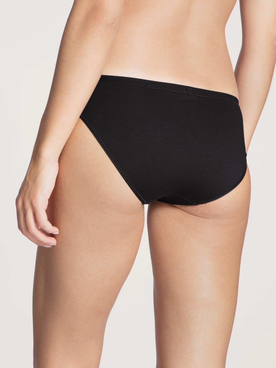 Women model is wearing Brief made of Cotton in Black, Unicoloured from the Natural Comfort series by CALIDA, Back view
