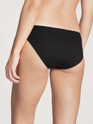 Women model is wearing Brief made of Cotton in Black, Unicoloured from the Natural Comfort series by CALIDA, Back view