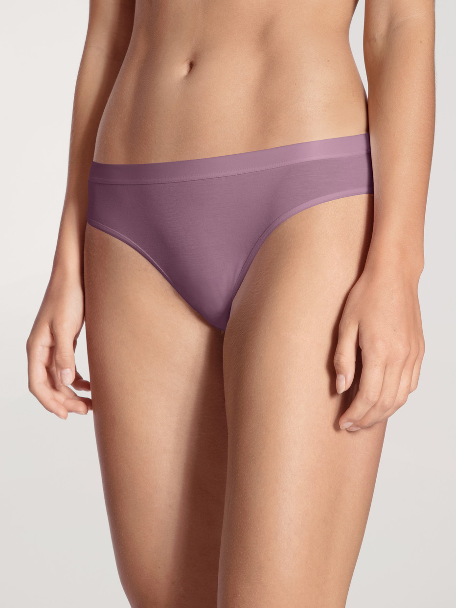 Damen-Model trägt Slip, regular cut aus Baumwolle in Violett, Einfarbig aus Serie Natural Joy Xtra von CALIDA, Vorderansicht
