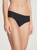 Damen-Model trägt Slip, regular cut aus Baumwolle in Schwarz, Einfarbig aus Serie Natural Comfort von CALIDA, Vorderansicht