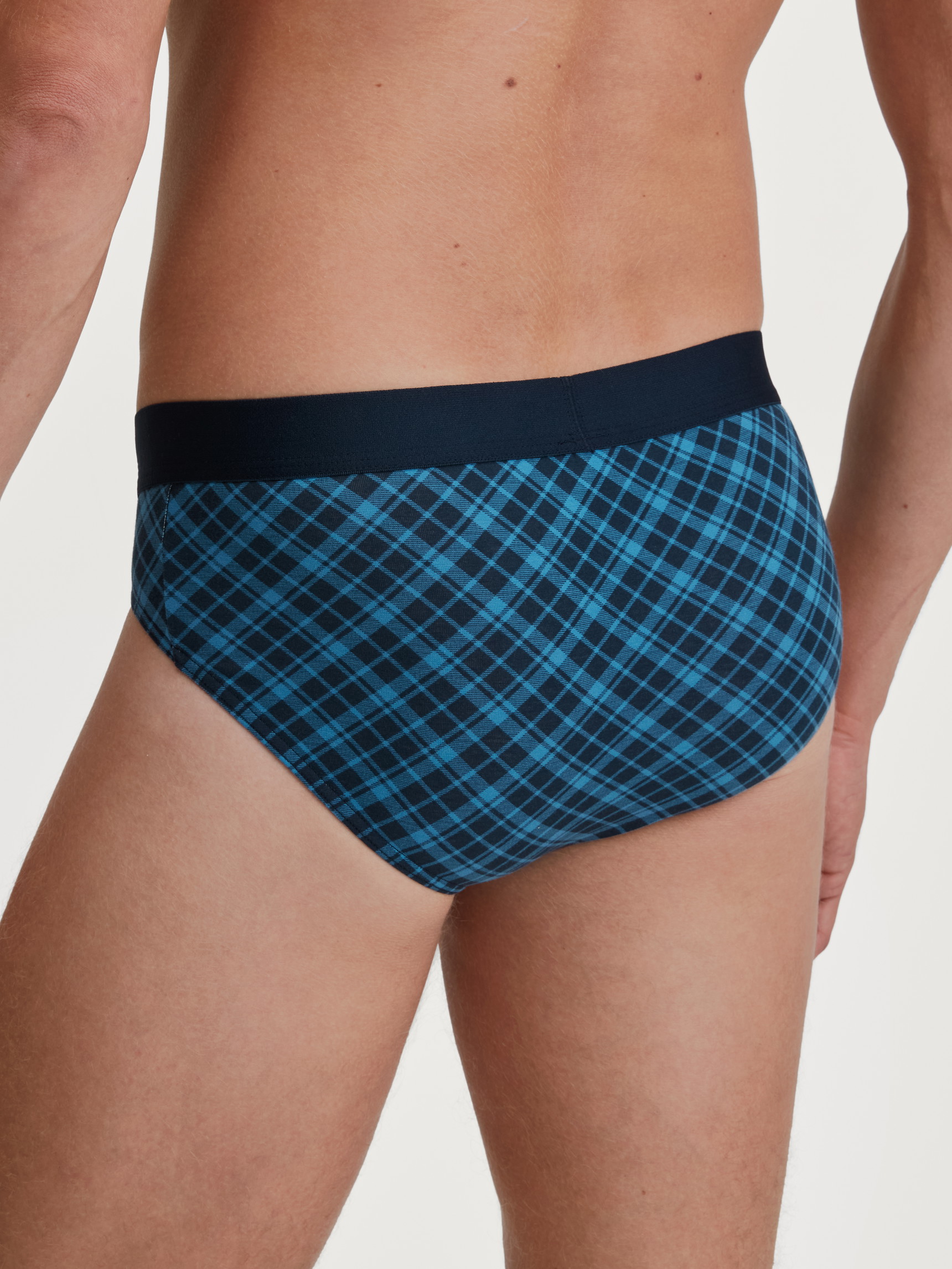 Herren-Model trägt Slip mit Softgummibund aus Baumwolle in Blau, Kariert aus Serie Cotton Code Design von CALIDA, Rückansicht