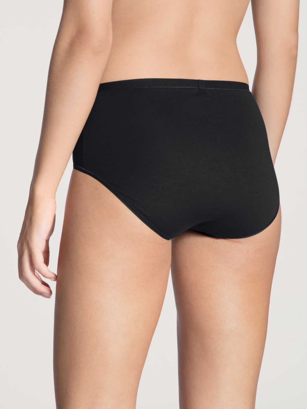 Women model is wearing Brief made of Cotton in Black, Unicoloured from the Natural Comfort series by CALIDA, Back view