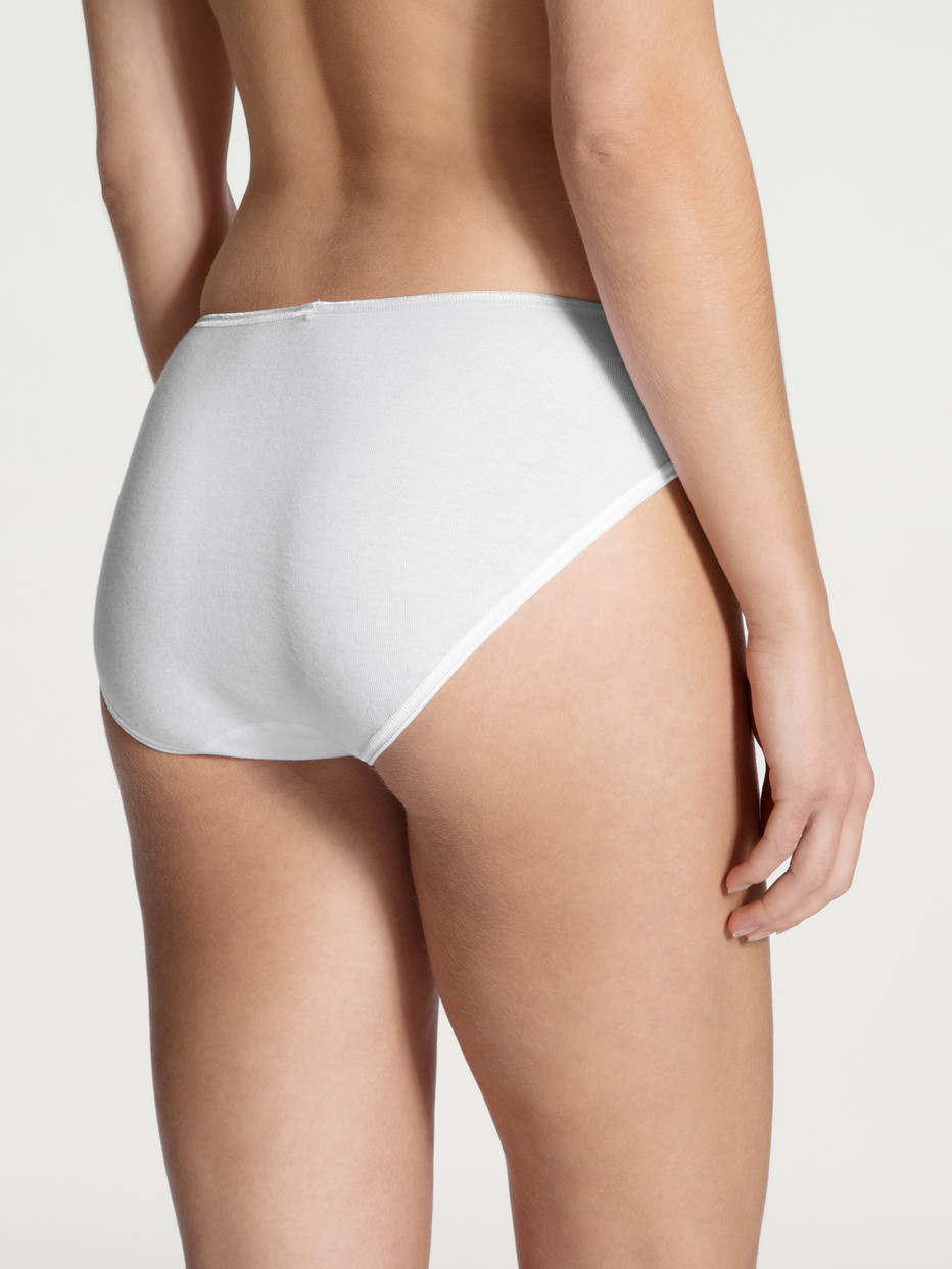Damen-Model trägt Minislip, hoch geschnitten aus 100% Baumwolle in Weiß, Einfarbig aus Serie Feminin Sense von CALIDA, Rückansicht