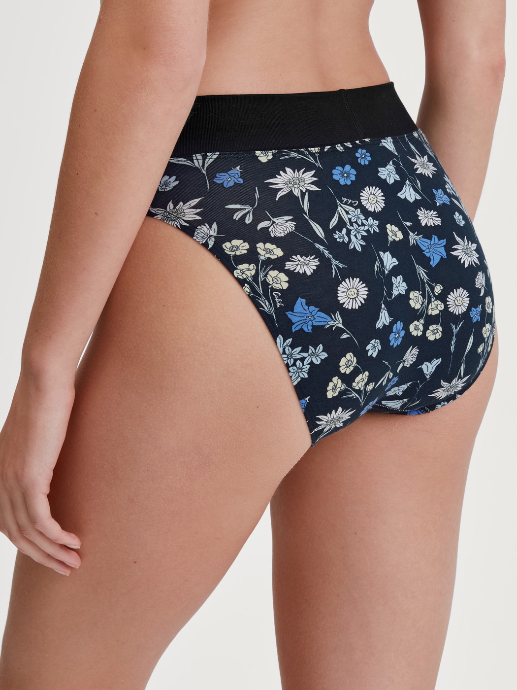 Women model is wearing Brief, high waist made of Cotton in Black, Floral from the Elastic Trend series by CALIDA, Back view