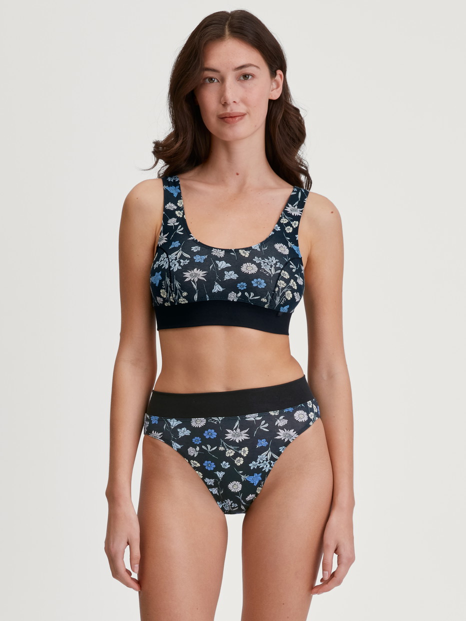 Damen-Model trägt Slip mit Softbund, high waist aus Baumwolle in Schwarz, Floral aus Serie Elastic Trend von CALIDA, Outfit