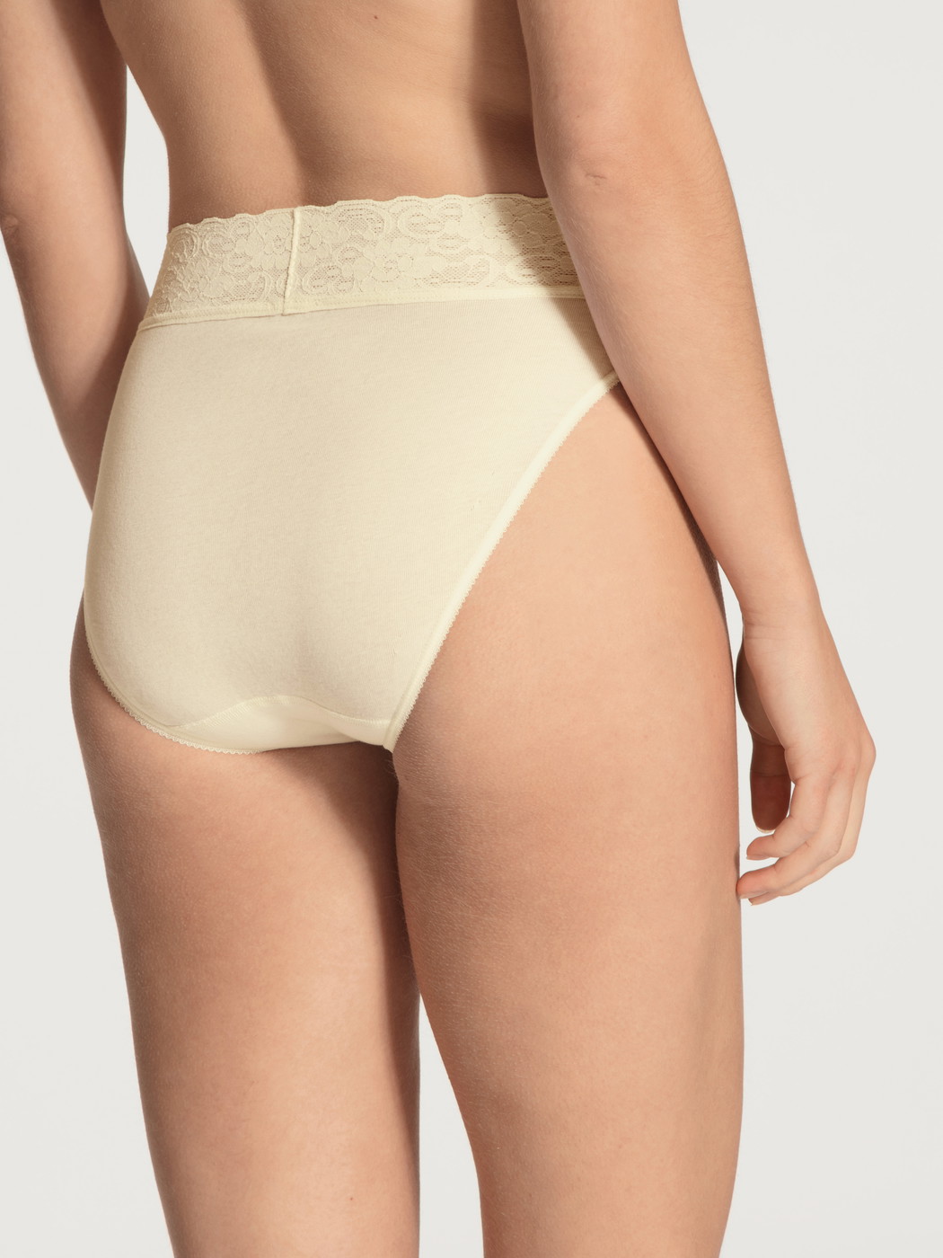 Damen-Model trägt Jazzpant aus 100% Baumwolle in Gelb, Spitze aus Serie Iconics von CALIDA, Rückansicht
