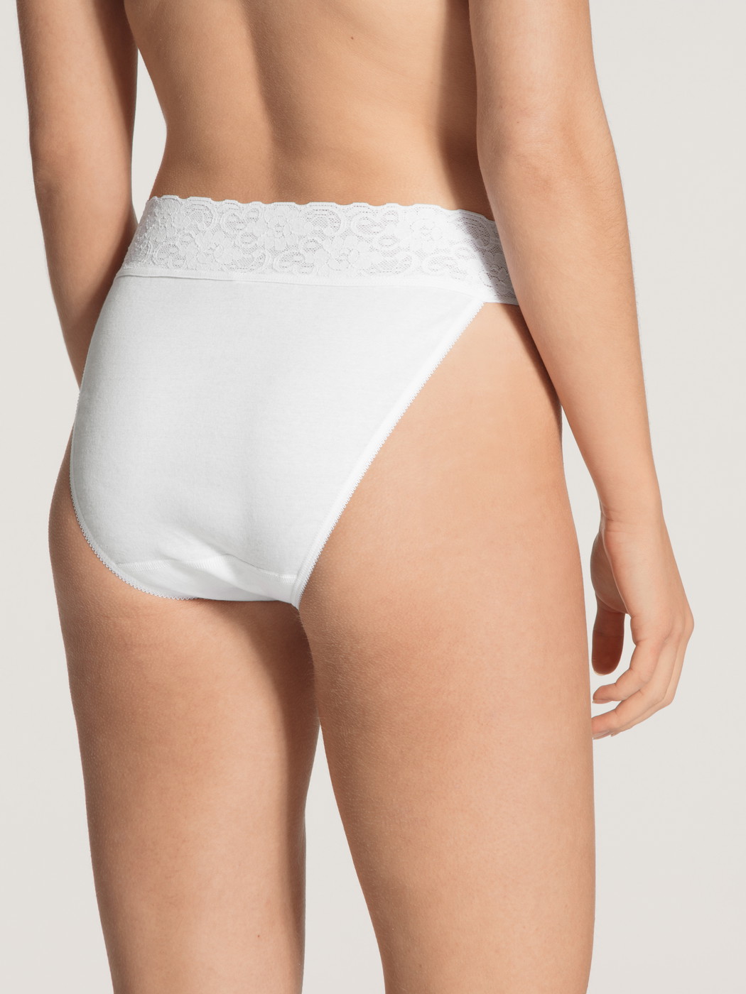 Women model is wearing Tanga made of 100% Cotton in White, Lace from the Iconics series by CALIDA, Back view