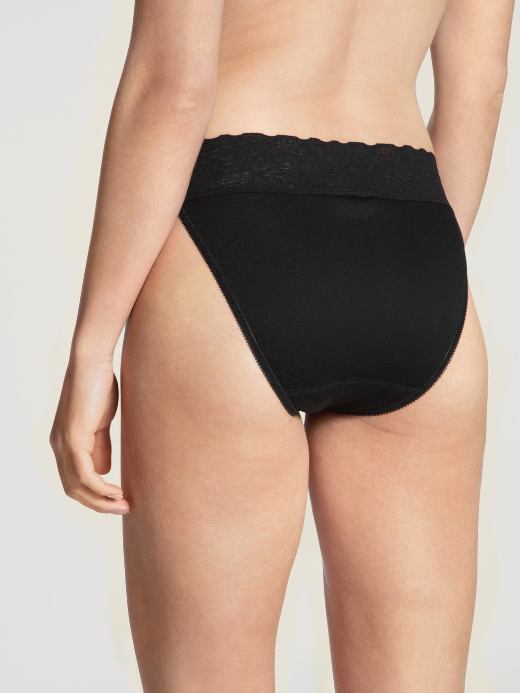 Le mannequin Femme porte le/la Culotte en 100% coton de couleur Noir, Dentelle, de la série Iconics de CALIDA, Vue arrière