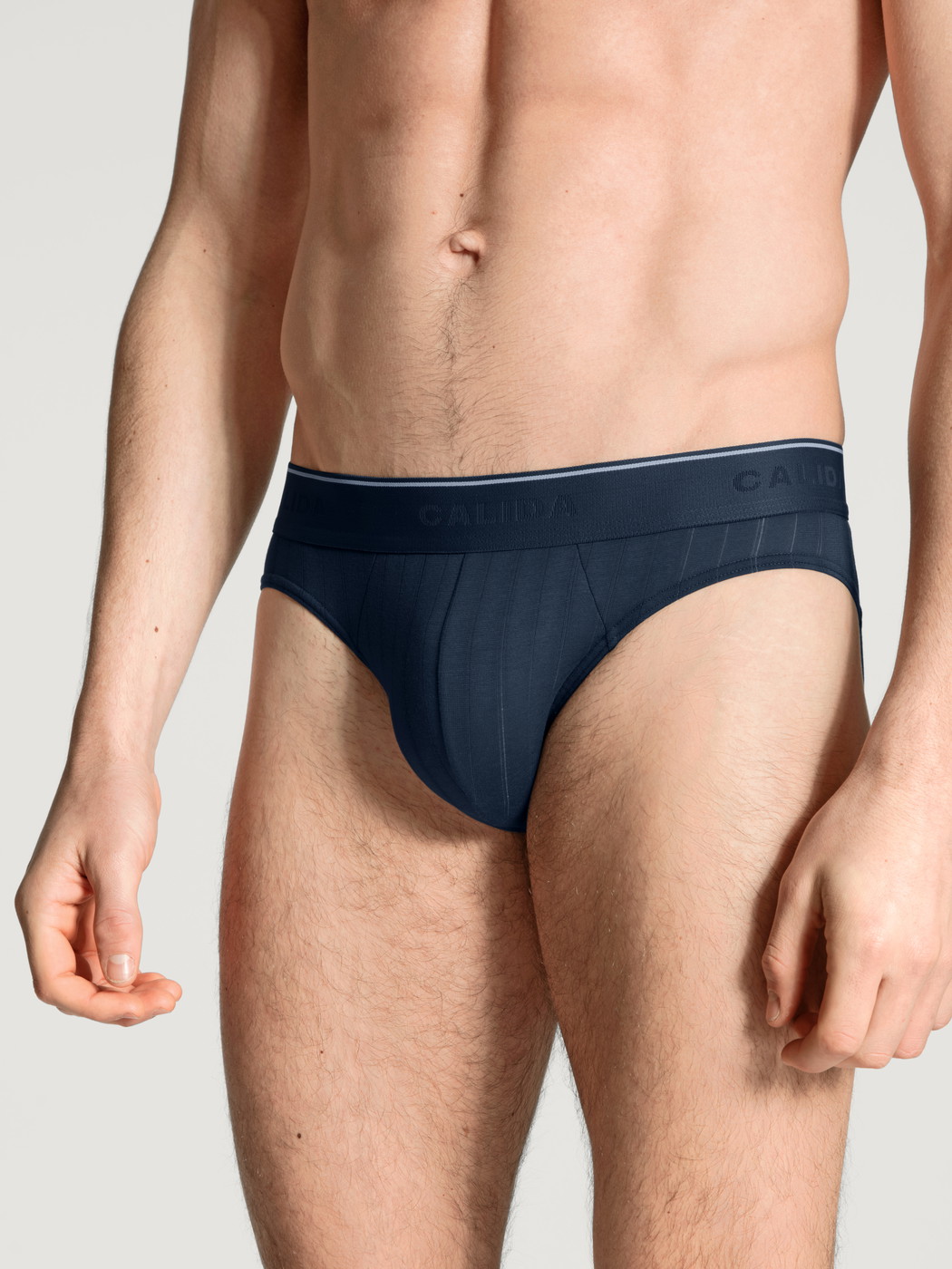 Herren-Model trägt Mini-Slip, Elastikbund aus Baumwolle in Blau, Einfarbig aus Serie Pure & Style von CALIDA, Vorderansicht