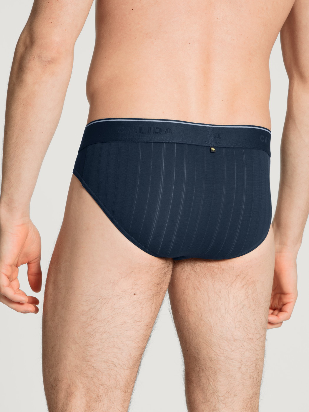 Herren-Model trägt Mini-Slip, Elastikbund aus Baumwolle in Blau, Einfarbig aus Serie Pure & Style von CALIDA, Rückansicht