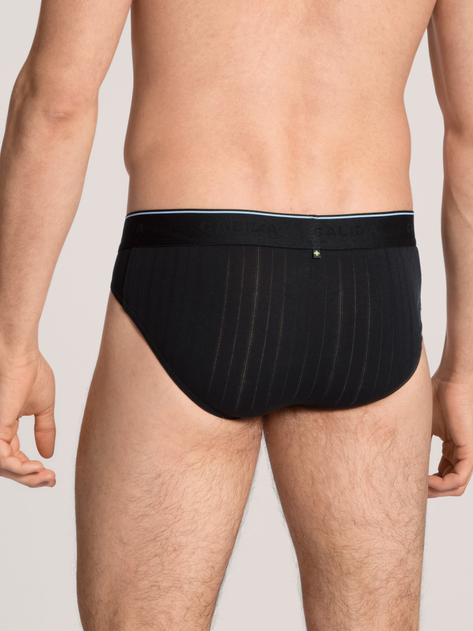 Herren-Model trägt Mini-Slip, Elastikbund aus Baumwolle in Schwarz, Einfarbig aus Serie Pure & Style von CALIDA, Rückansicht