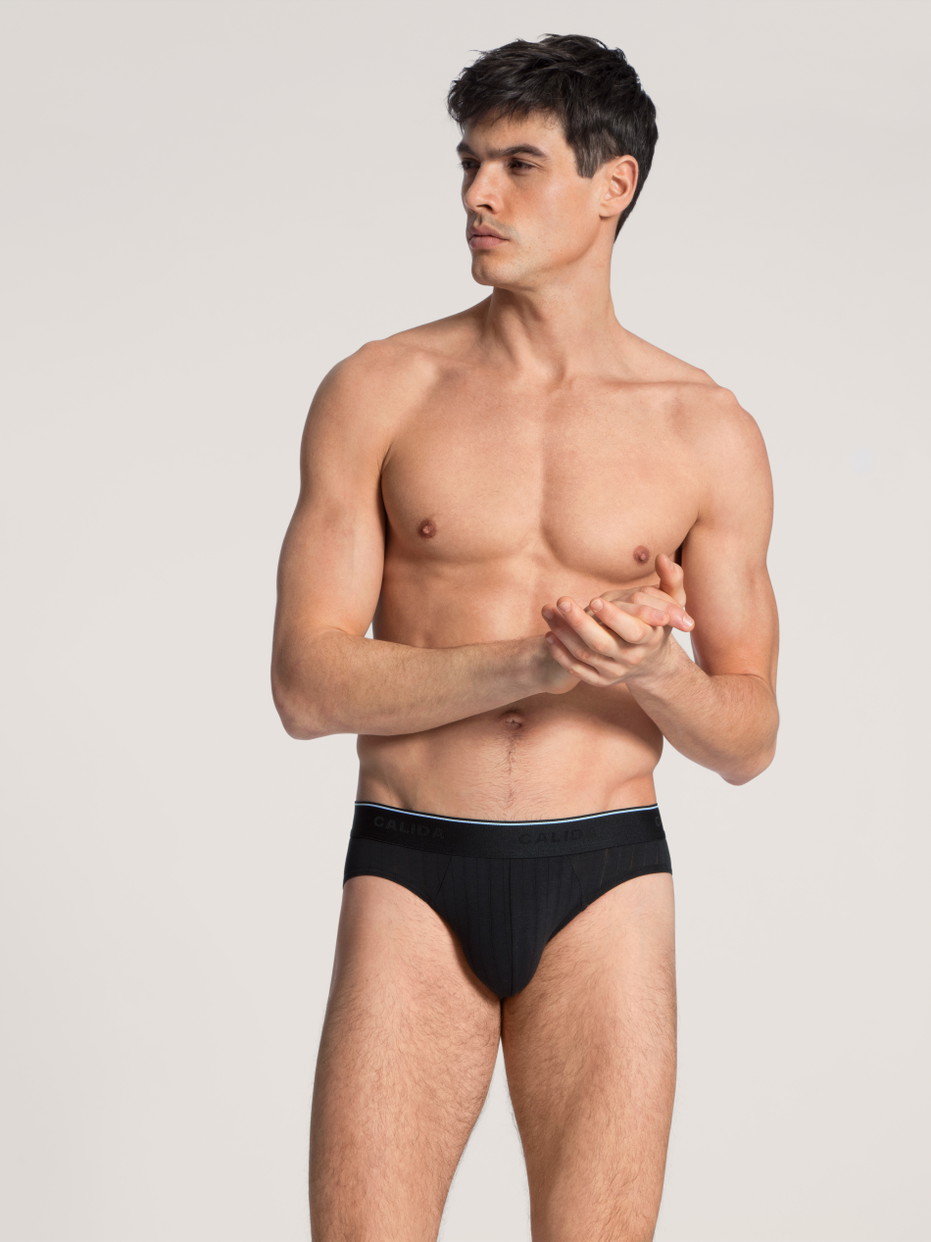 Herren-Model trägt Mini-Slip, Elastikbund aus Baumwolle in Schwarz, Einfarbig aus Serie Pure & Style von CALIDA, Outfit, Vorderansicht