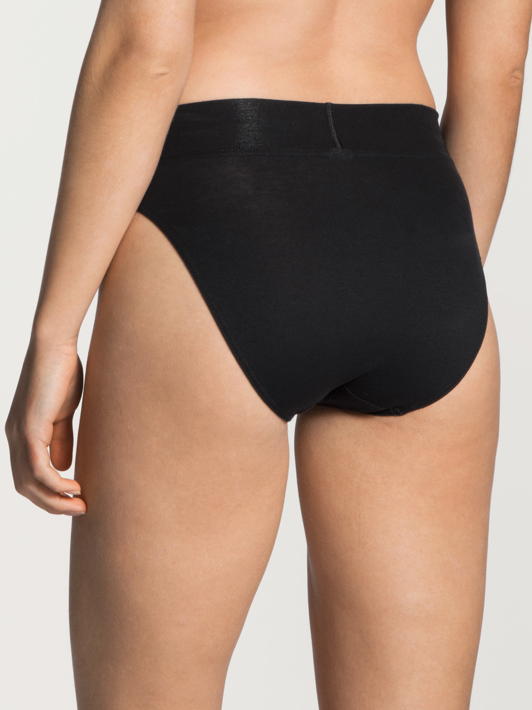 Women model is wearing Brief, high waist made of Cotton in Black, Unicoloured from the Elastic series by CALIDA, Back view, White background