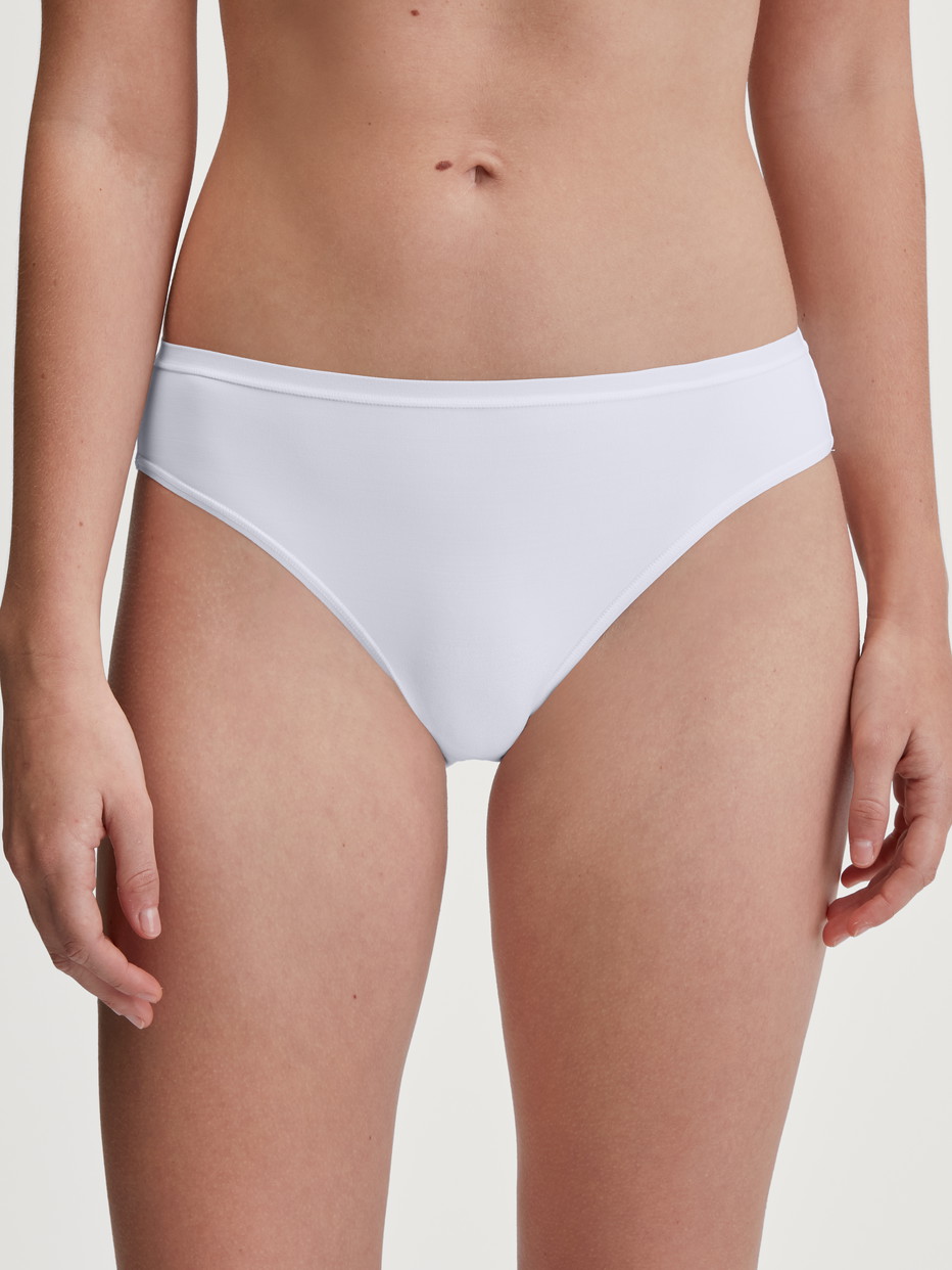 Damen-Model trägt Slip, regular cut aus Polyamid in Weiß, Einfarbig aus Serie Sleek Skin von CALIDA, Vorderansicht