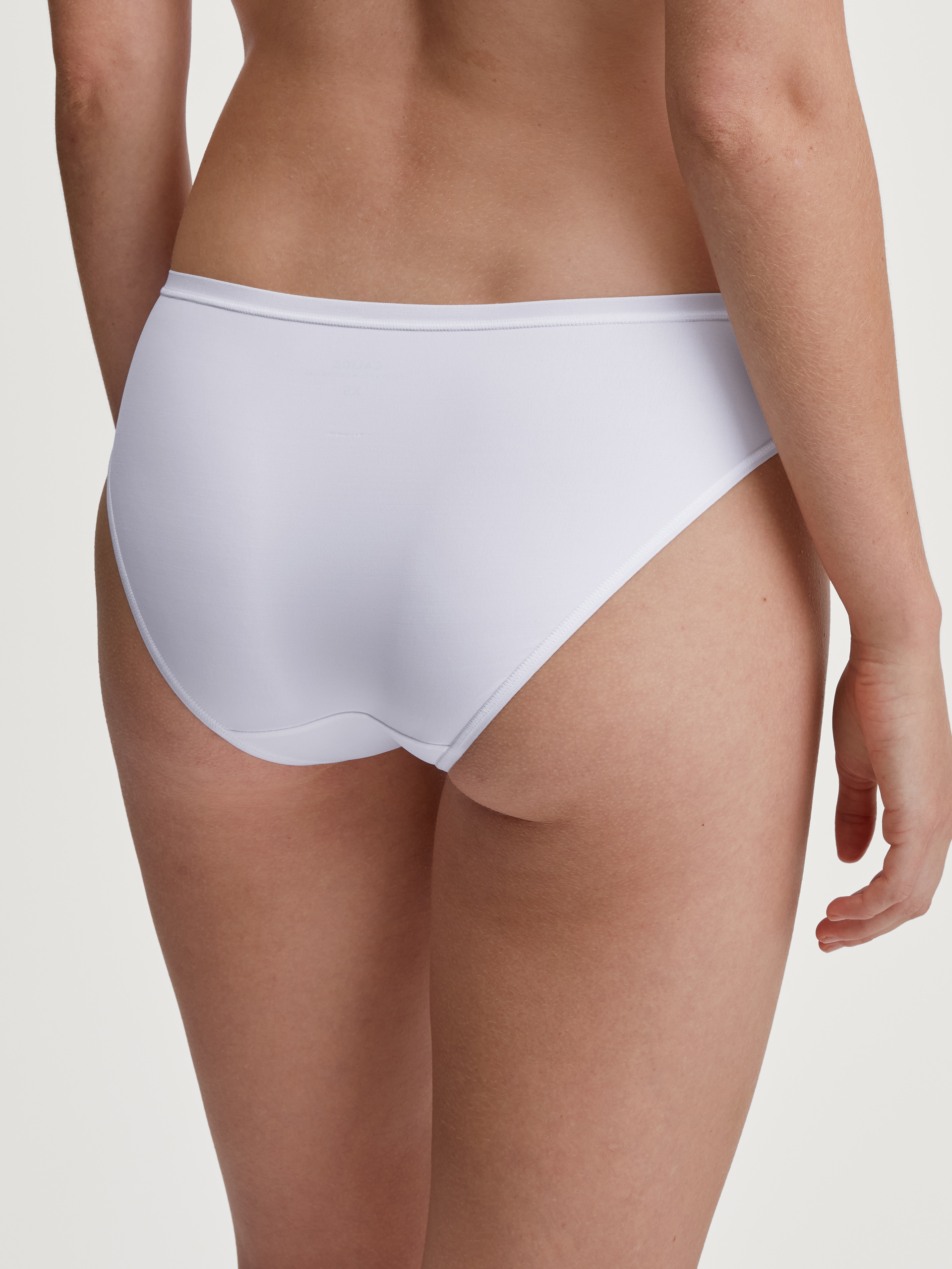 Women model is wearing Brief, regular cut made of Polyamide in White, Unicoloured from the Sleek Skin series by CALIDA, Back view