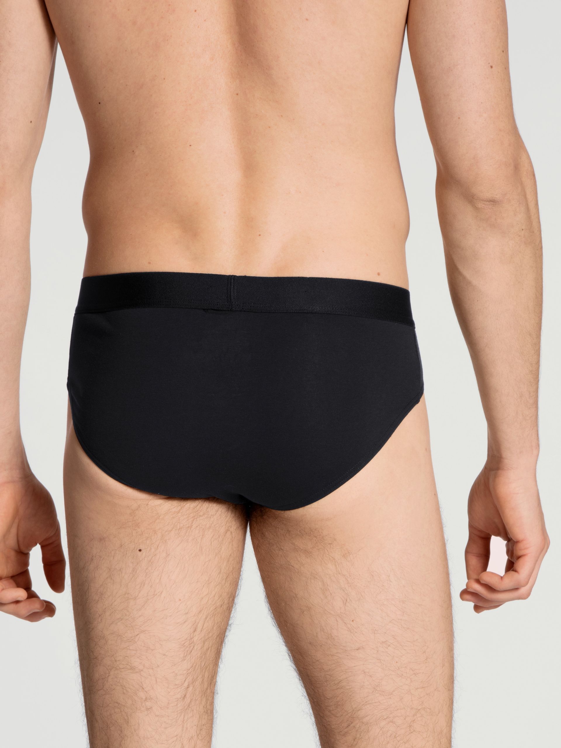 La modella / Il modello Uomo indossa Slip in Cotone di colore Nero, Tinta unita, della serie Cotton Code di CALIDA, Vista posteriore