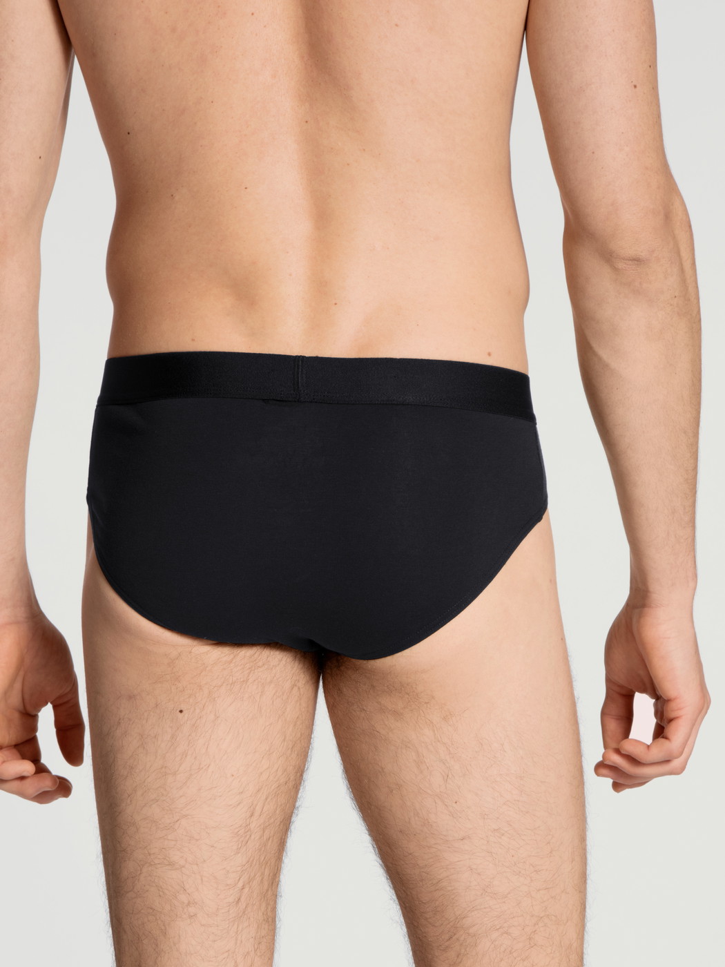 La modella / Il modello Uomo indossa Slip in Cotone di colore Nero, Tinta unita, della serie Cotton Code di CALIDA, Vista posteriore