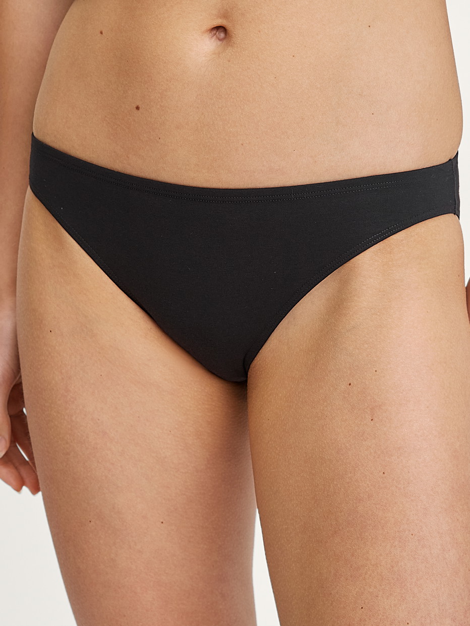 La modella / Il modello Donna indossa Slip in Cotone di colore Nero, Tinta unita, della serie Essential Cotton di CALIDA, Vista frontale