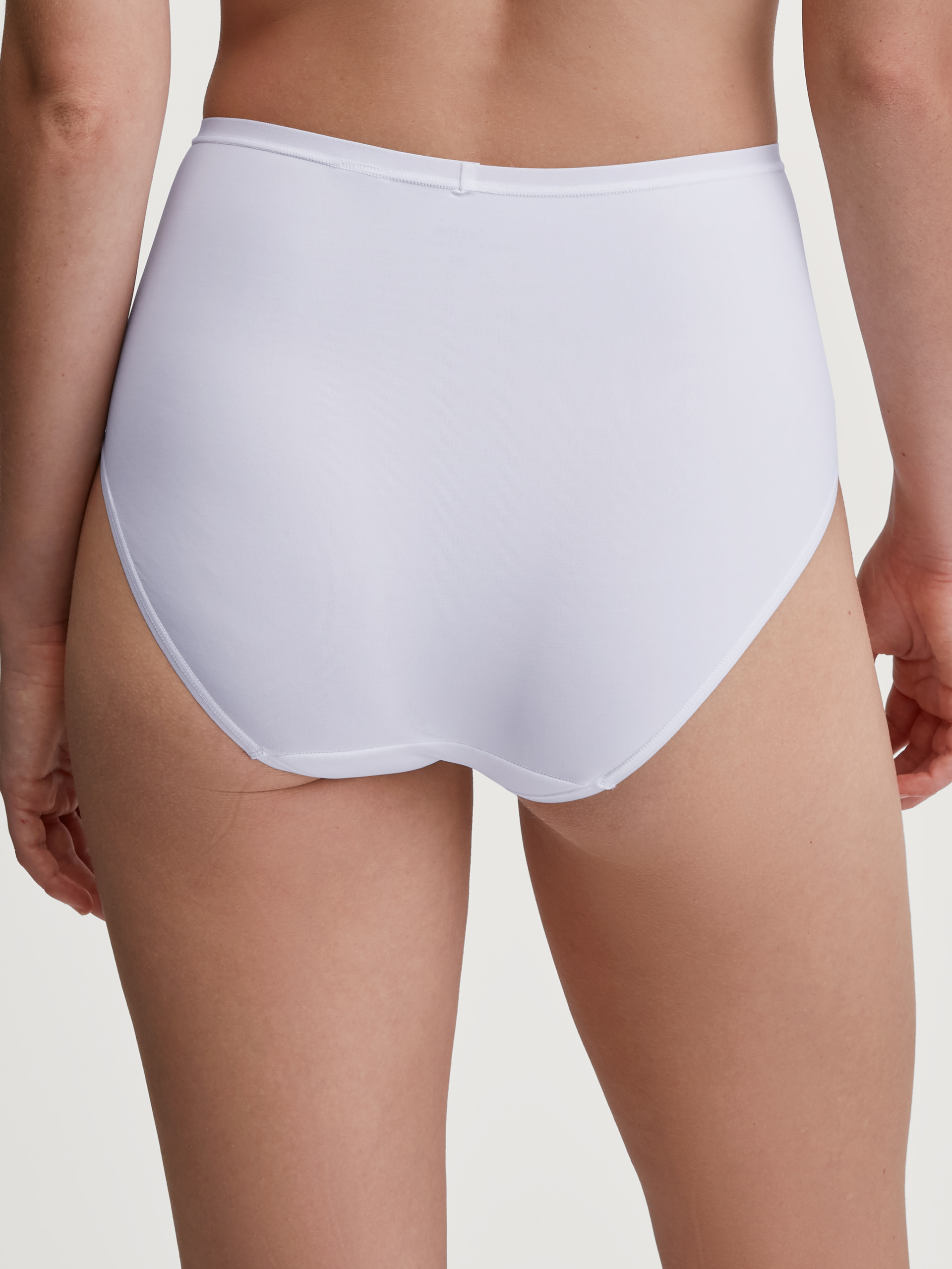 Women model is wearing Brief, high waist made of Polyamide in White, Unicoloured from the Sleek Skin series by CALIDA, Back view