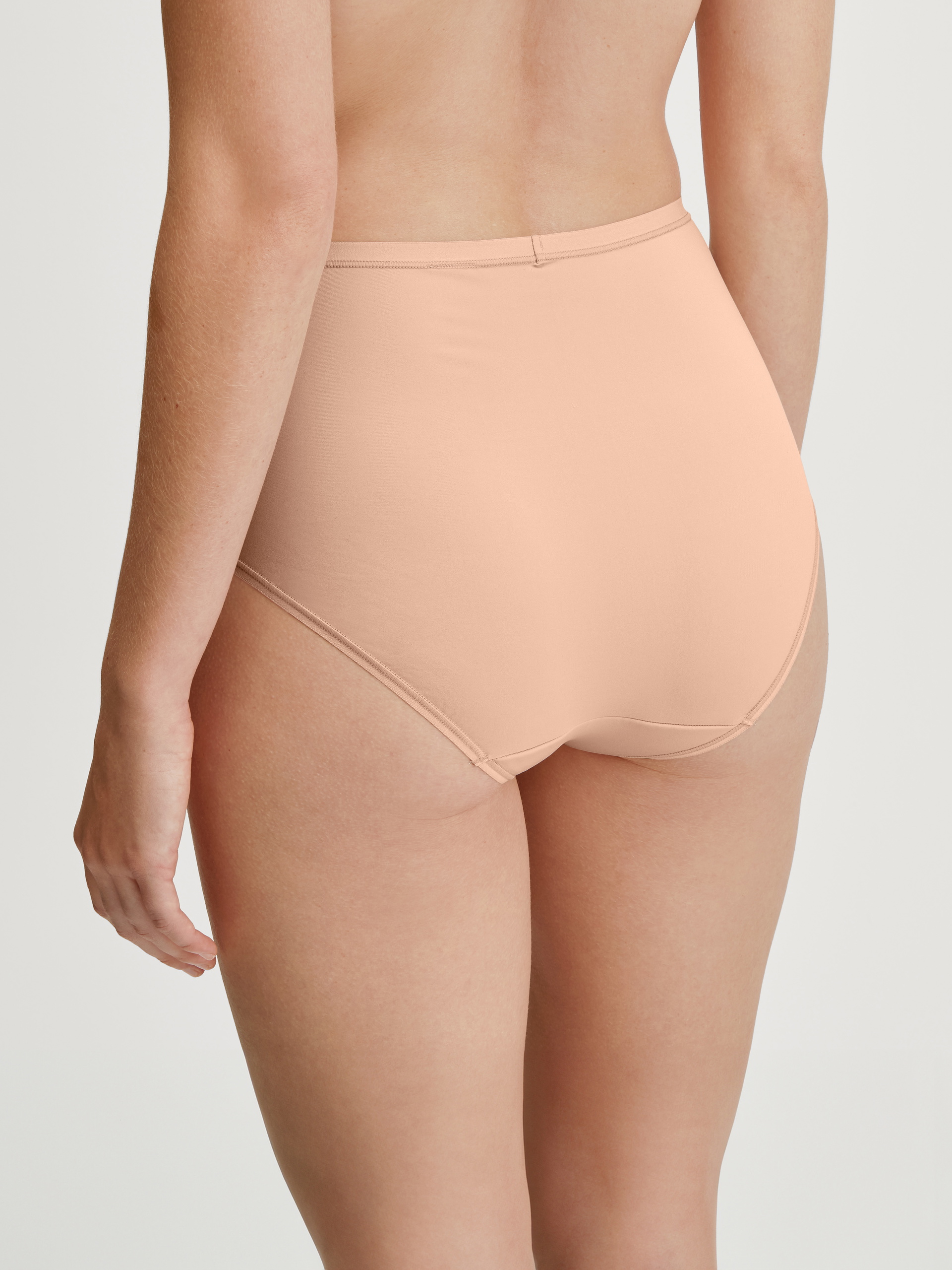 Women model is wearing Brief, high waist made of Polyamide in Beige, Unicoloured from the Sleek Skin series by CALIDA, Back view
