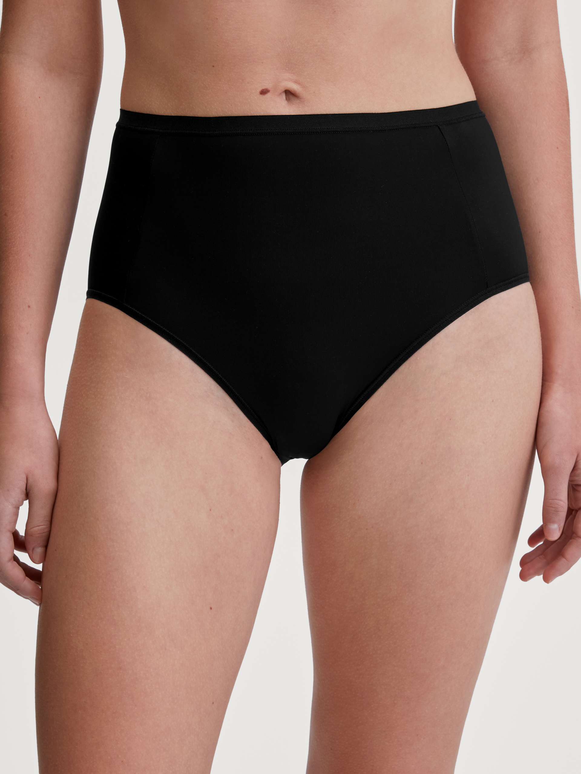 La modella / Il modello Donna indossa Slip, high waist in Poliammide di colore Nero, Tinta unita, della serie Sleek Skin di CALIDA, Vista frontale
