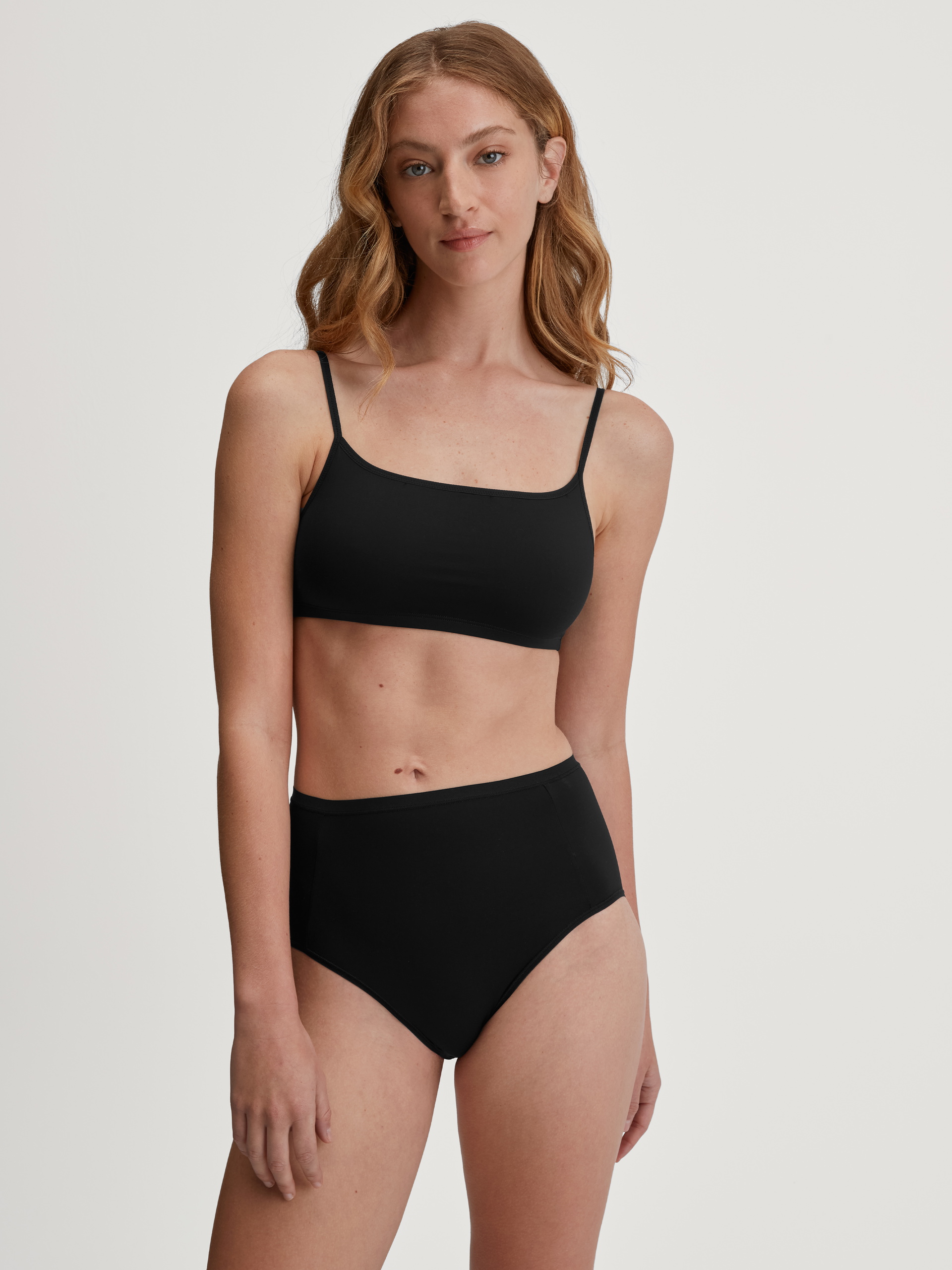 La modella / Il modello Donna indossa Slip, high waist in Poliammide di colore Nero, Tinta unita, della serie Sleek Skin di CALIDA, Abbigliamento