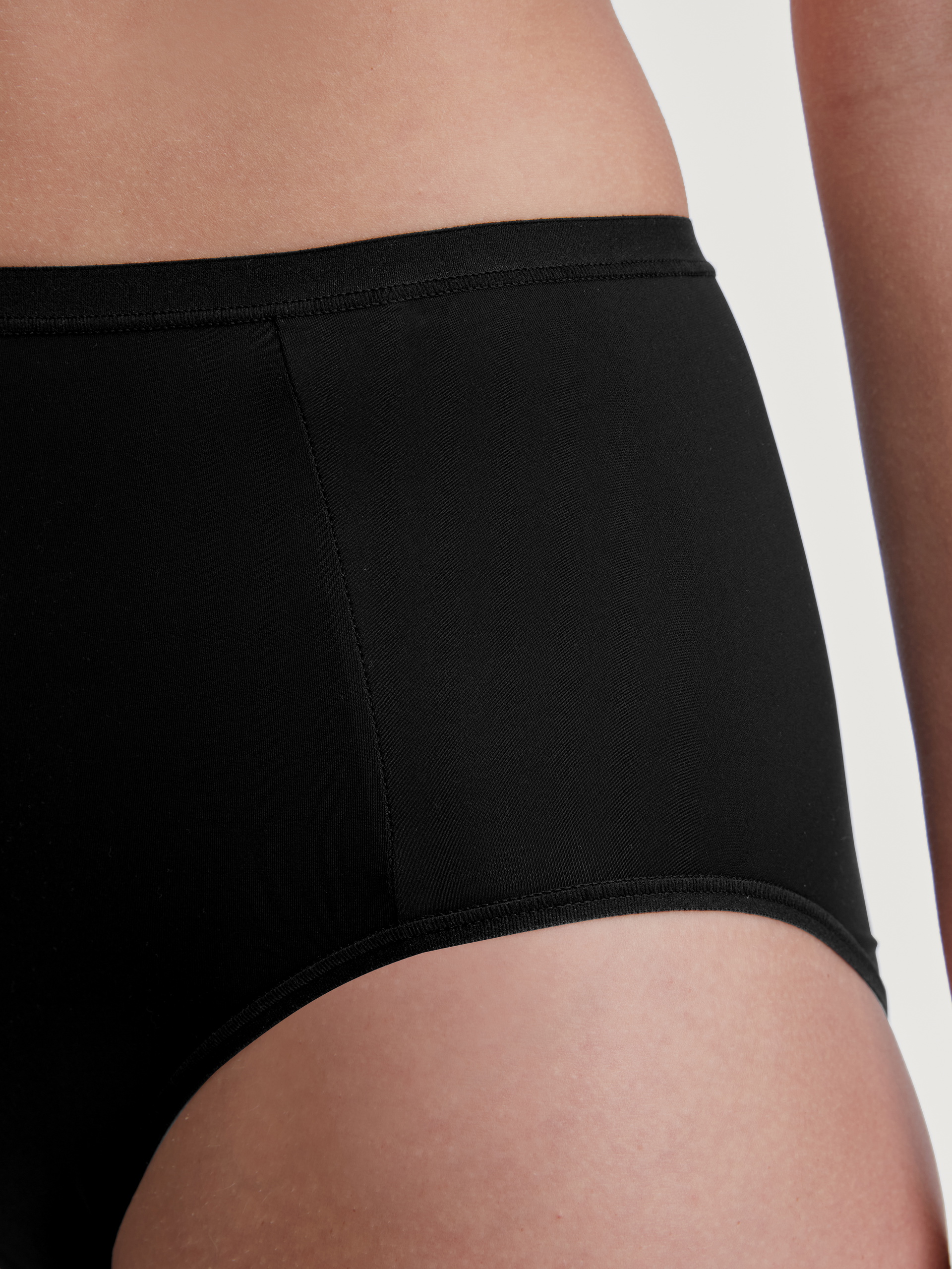 La modella / Il modello Donna indossa Slip, high waist in Poliammide di colore Nero, Tinta unita, della serie Sleek Skin di CALIDA, Dettaglio