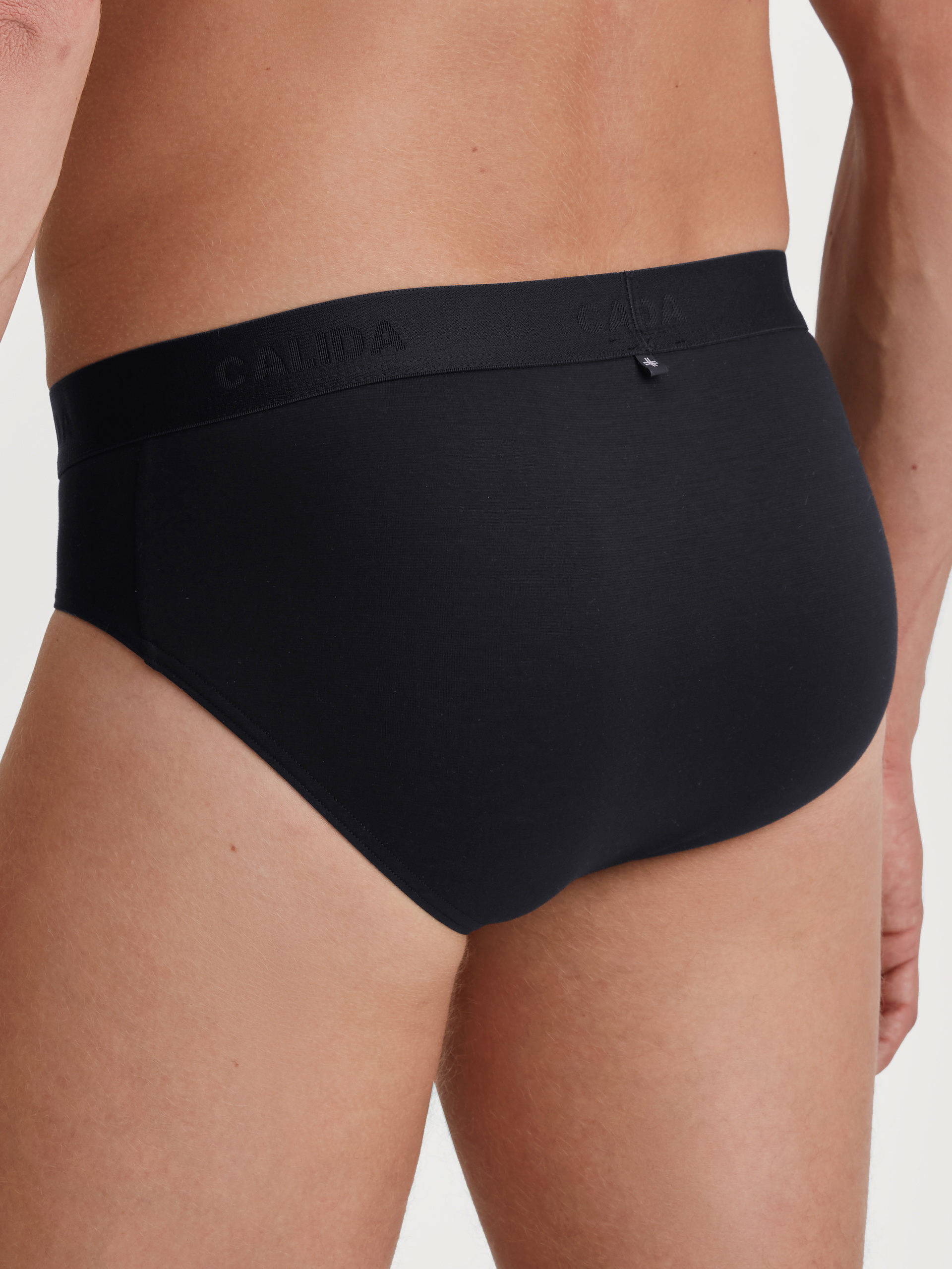 La modella / Il modello Uomo indossa Slip in TENCEL™ di colore Nero, Tinta unita, della serie Natural Cooling di CALIDA, Vista posteriore