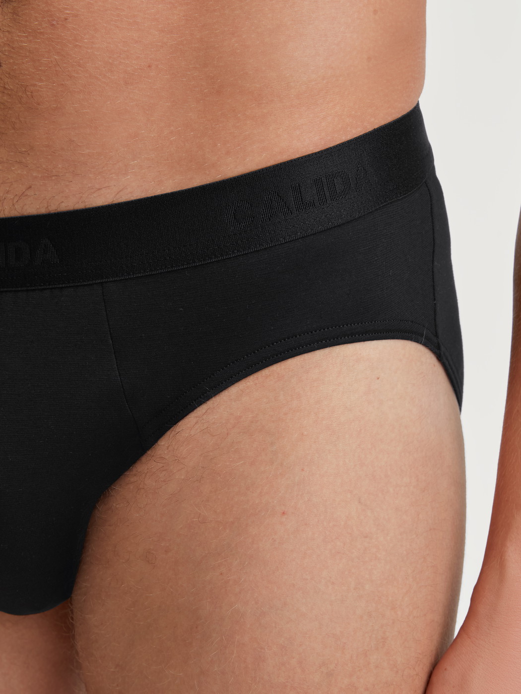 Herren-Model trägt Slip aus TENCEL™ in Schwarz, Einfarbig aus Serie Natural Cooling von CALIDA, Detail