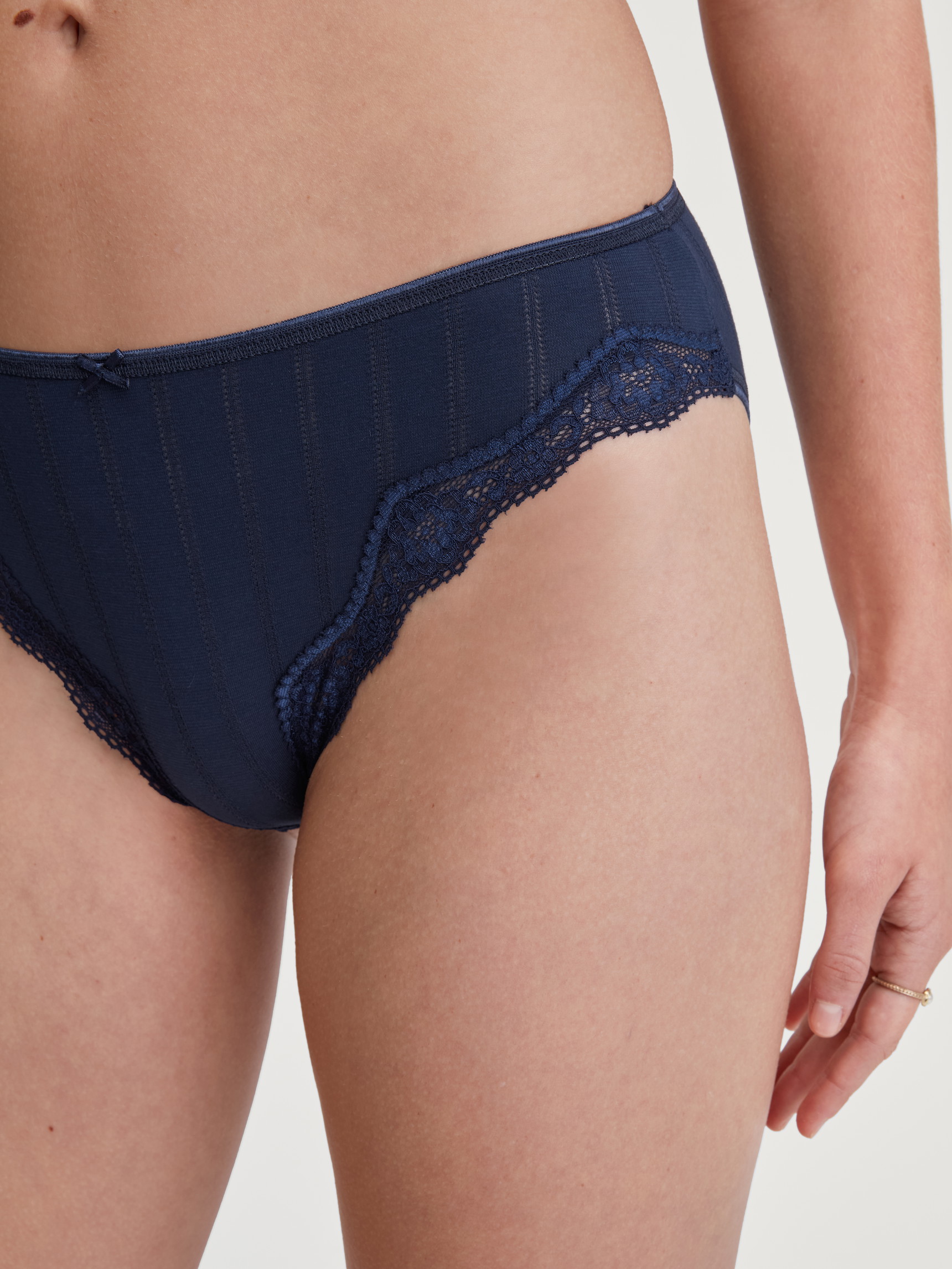 La modella / Il modello Donna indossa Slip, regular cut in Cotone di colore Blu, Pizzo, della serie Etude Toujours di CALIDA, Vista frontale