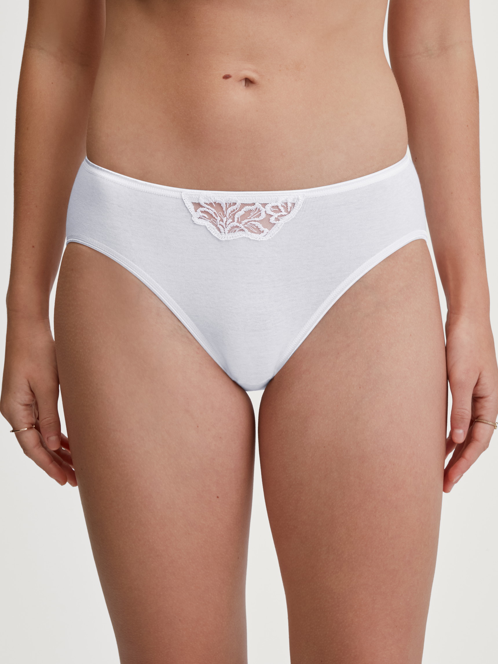 Damen-Model trägt Mini-Slip aus 100% Baumwolle in Weiß, Spitze aus Serie Cotton Desire von CALIDA, Vorderansicht