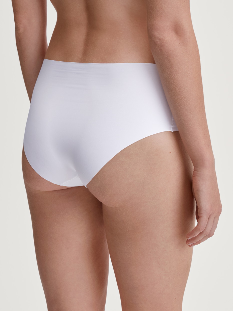 Damen-Model trägt Nahtloser Midi-Slip, Clean-Cut aus Polyamid in Weiß, Einfarbig aus Serie Sleek Skin von CALIDA, Rückansicht