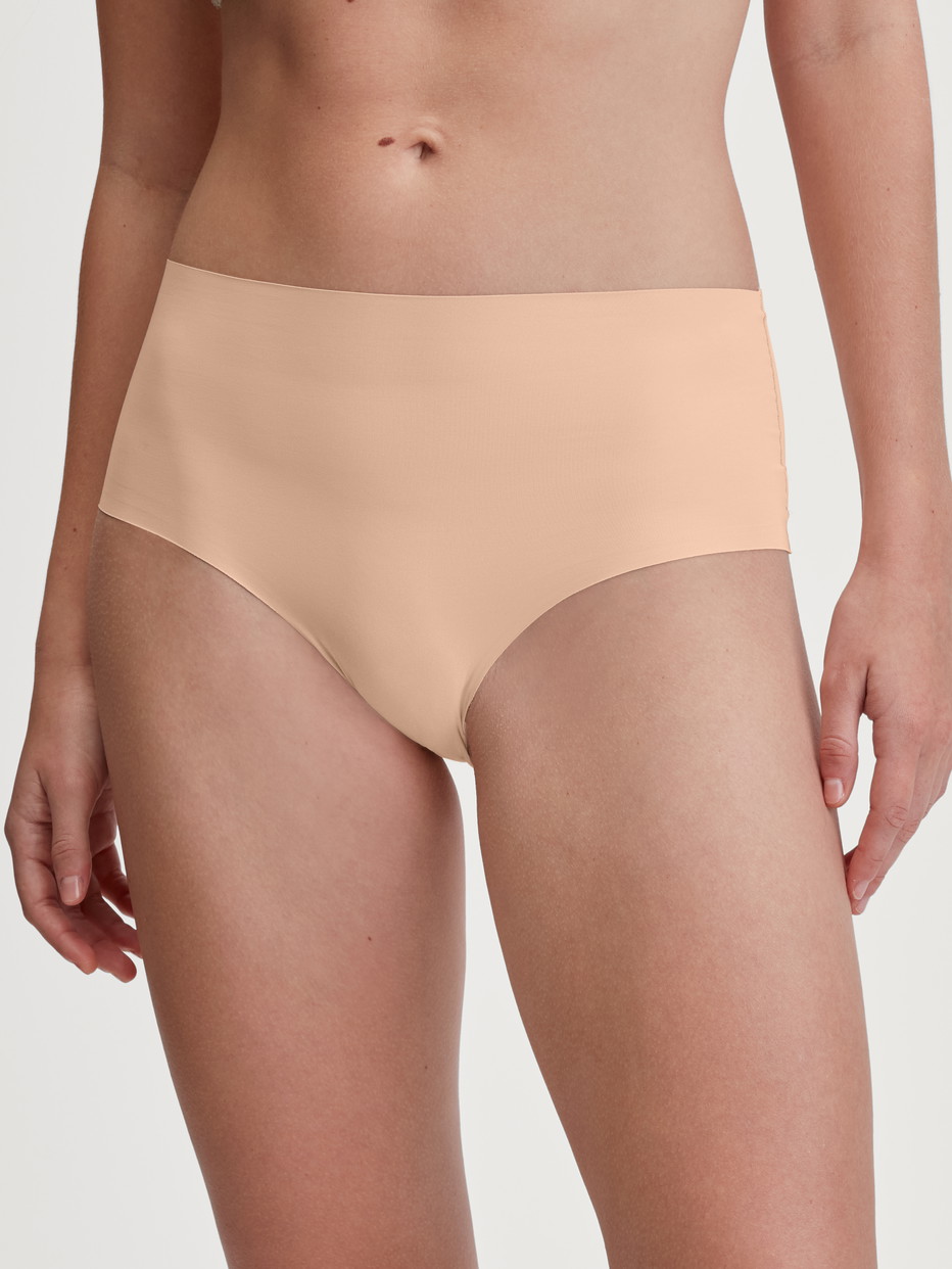 Damen-Model trägt Nahtloser Midi-Slip, Clean-Cut aus Polyamid in Beige, Einfarbig aus Serie Sleek Skin von CALIDA, Vorderansicht