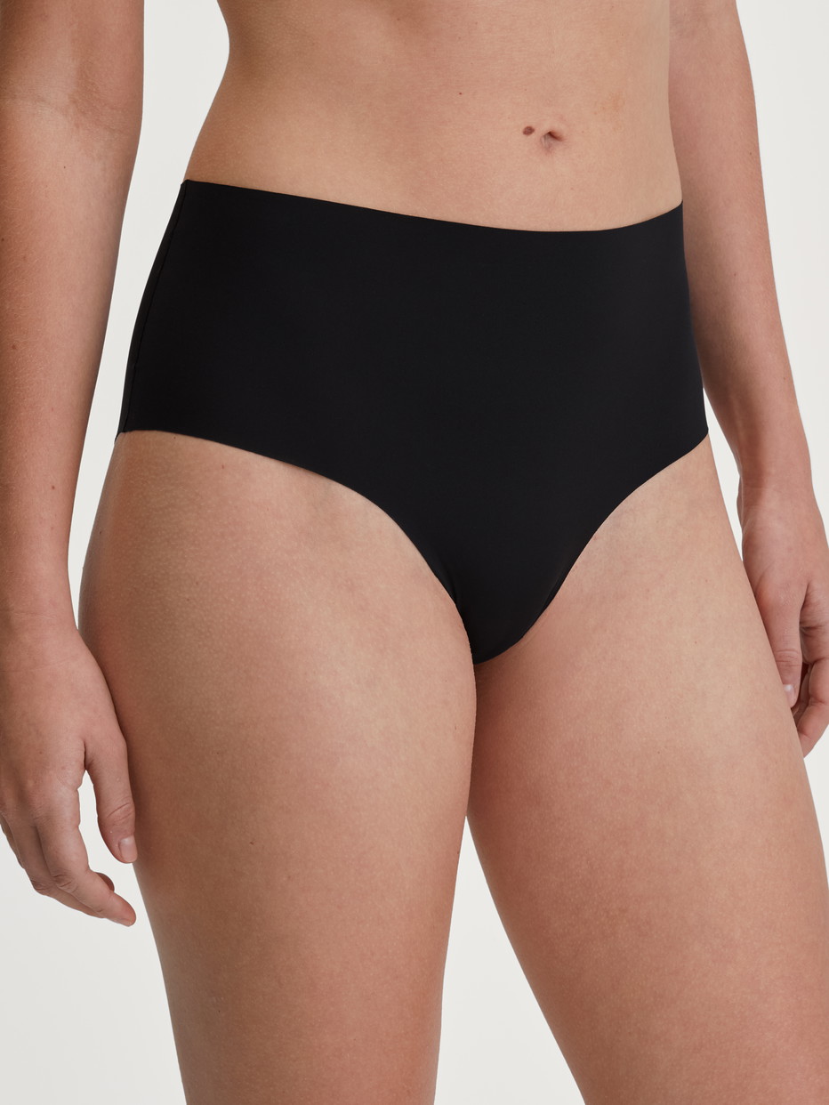 Damen-Model trägt Nahtloser Midi-Slip, Clean-Cut aus Polyamid in Schwarz, Einfarbig aus Serie Sleek Skin von CALIDA, Vorderansicht