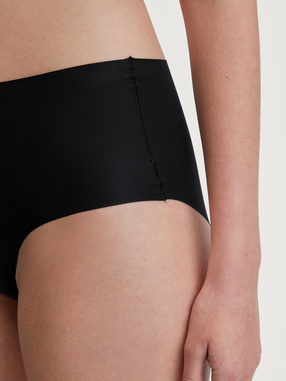 Damen-Model trägt Nahtloser Midi-Slip, Clean-Cut aus Polyamid in Schwarz, Einfarbig aus Serie Sleek Skin von CALIDA, Detail