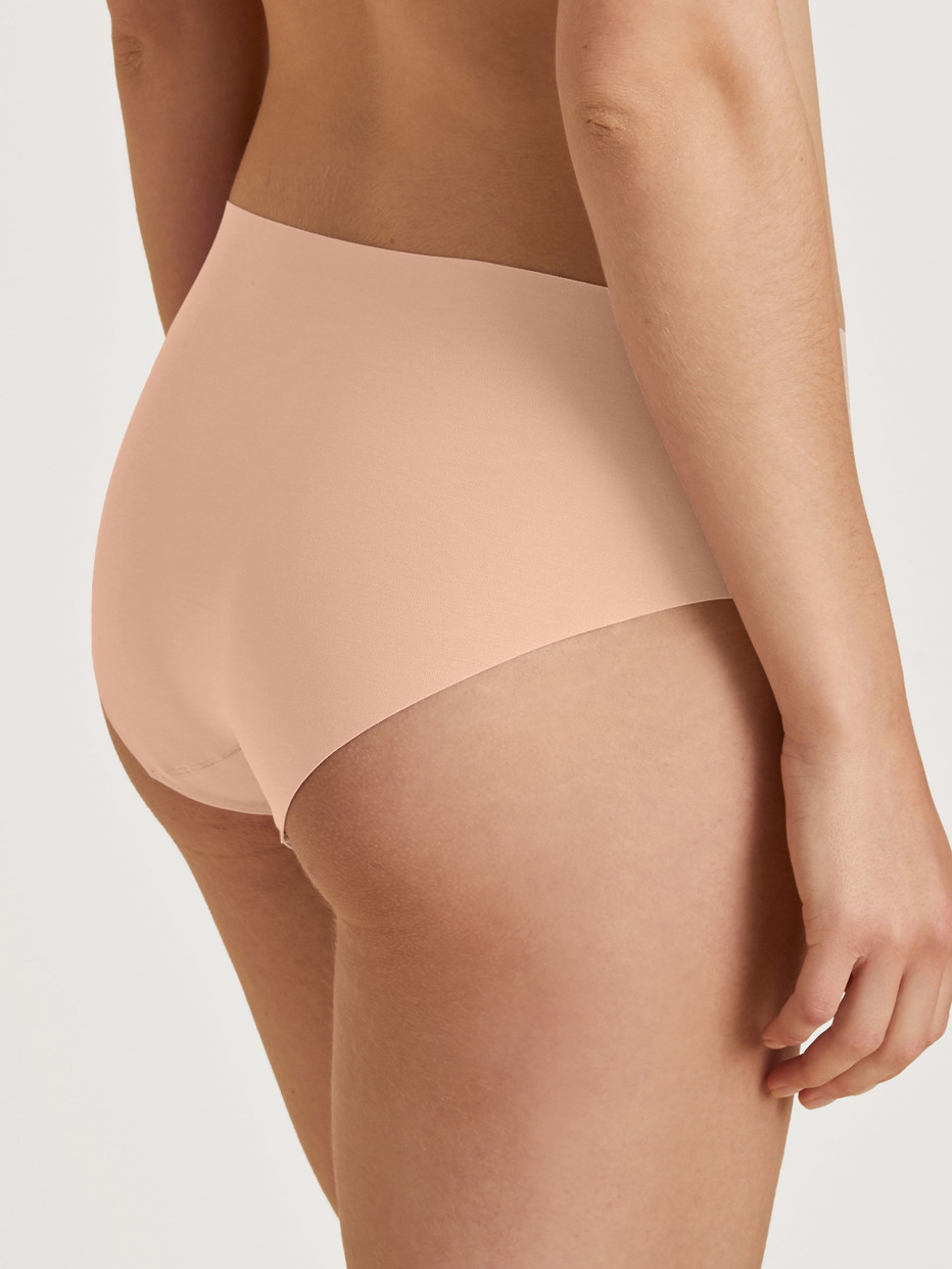 Damen-Model trägt Seamless-Midi-Slip aus Modal in Rosa, Einfarbig aus Serie Natural Skin von CALIDA, Rückansicht