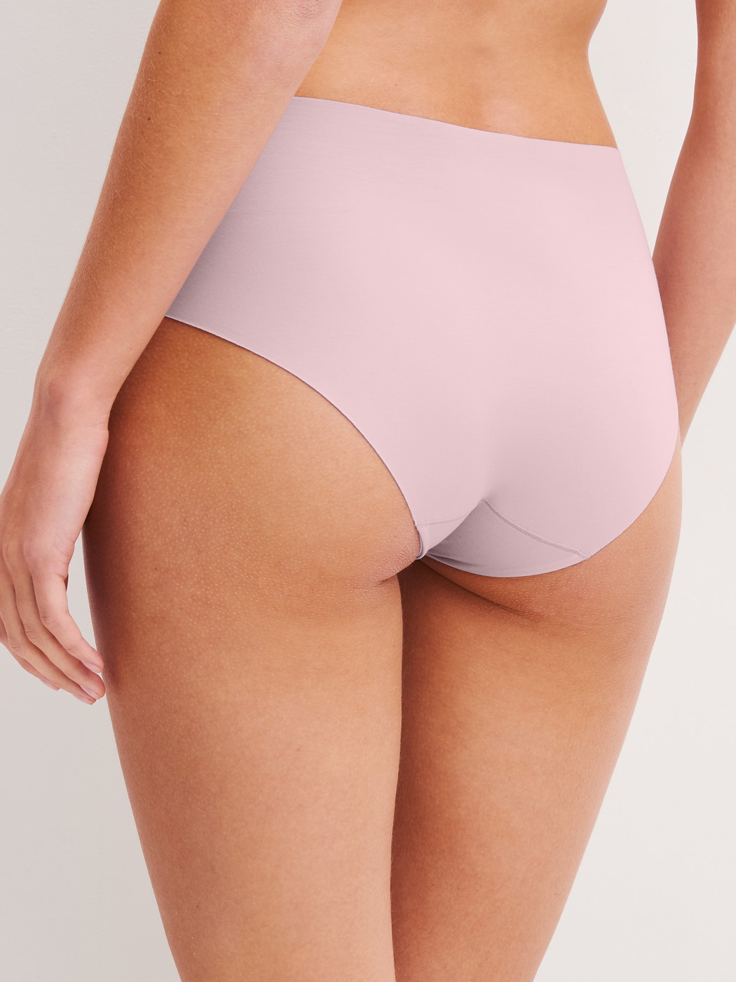 Damen-Model trägt Seamless-Midi-Slip aus Modal in Violett, Einfarbig aus Serie Natural Skin von CALIDA, Rückansicht