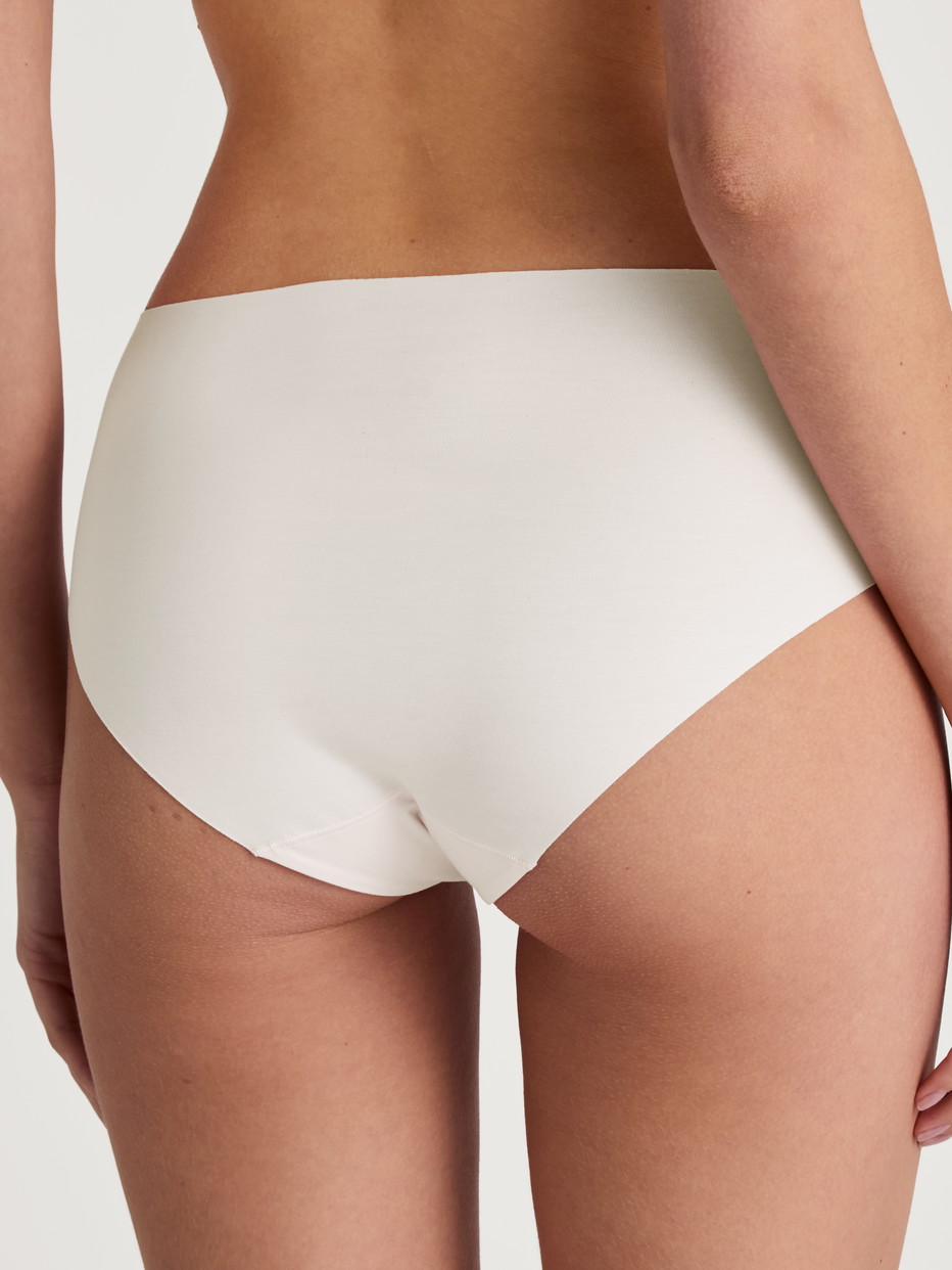 Damen-Model trägt Seamless-Midi-Slip aus Modal in Weiß, Einfarbig aus Serie Natural Skin von CALIDA, Rückansicht