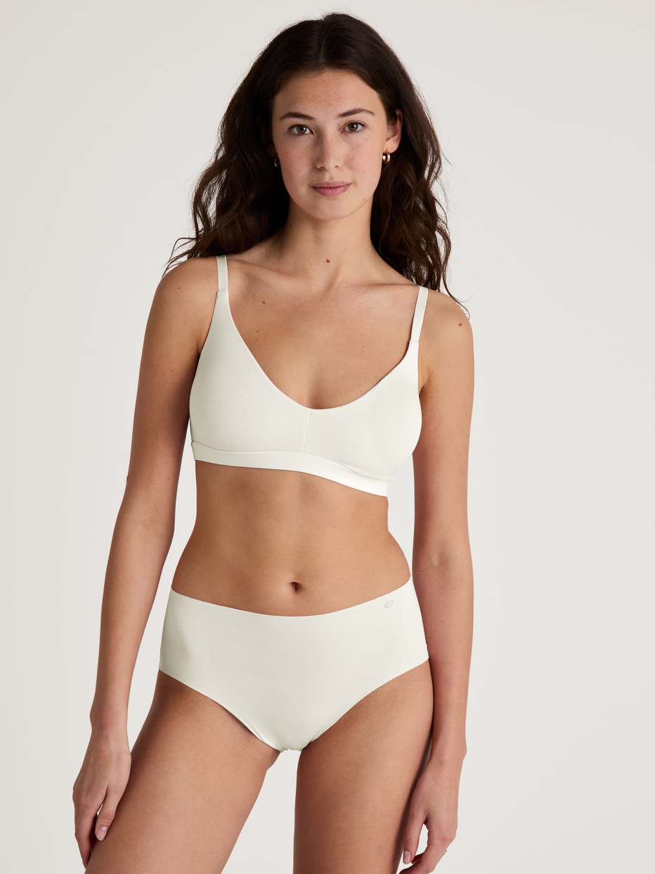 Damen-Model trägt Seamless-Midi-Slip aus Modal in Weiß, Einfarbig aus Serie Natural Skin von CALIDA, Outfit