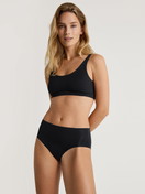 Damen-Model trägt Seamless-Midi-Slip aus Modal in Schwarz, Einfarbig aus Serie Natural Skin von CALIDA, Outfit