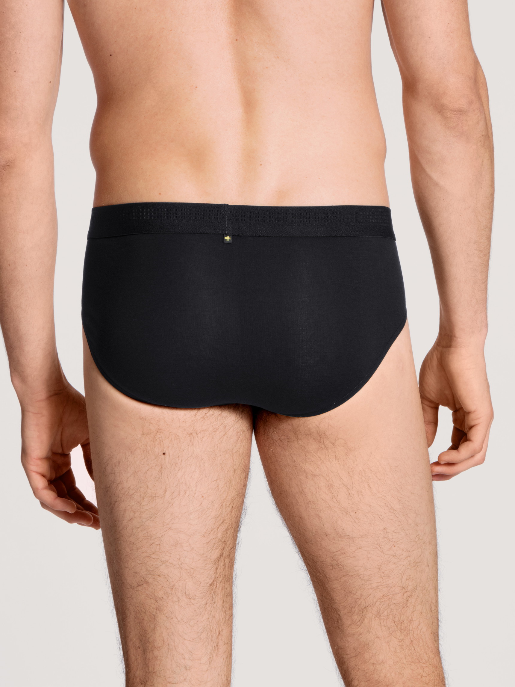 Herren-Model trägt Slip mit Softbund aus Lyocell in Schwarz, Einfarbig aus Serie Focus von CALIDA, Rückansicht