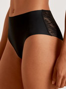 Damen-Model trägt Midislip aus Modal in Schwarz, Spitze aus Serie Natural Skin Lace von CALIDA, Vorderansicht