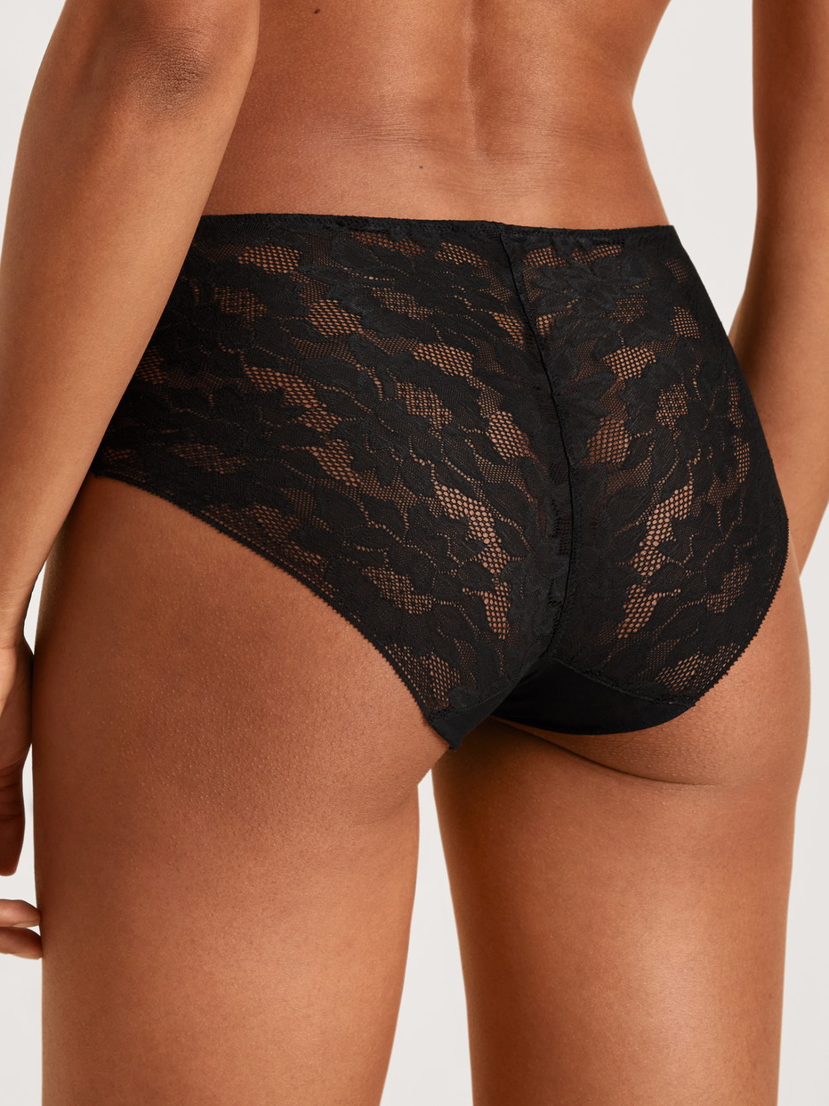 Damen-Model trägt Midislip aus Modal in Schwarz, Spitze aus Serie Natural Skin Lace von CALIDA, Rückansicht