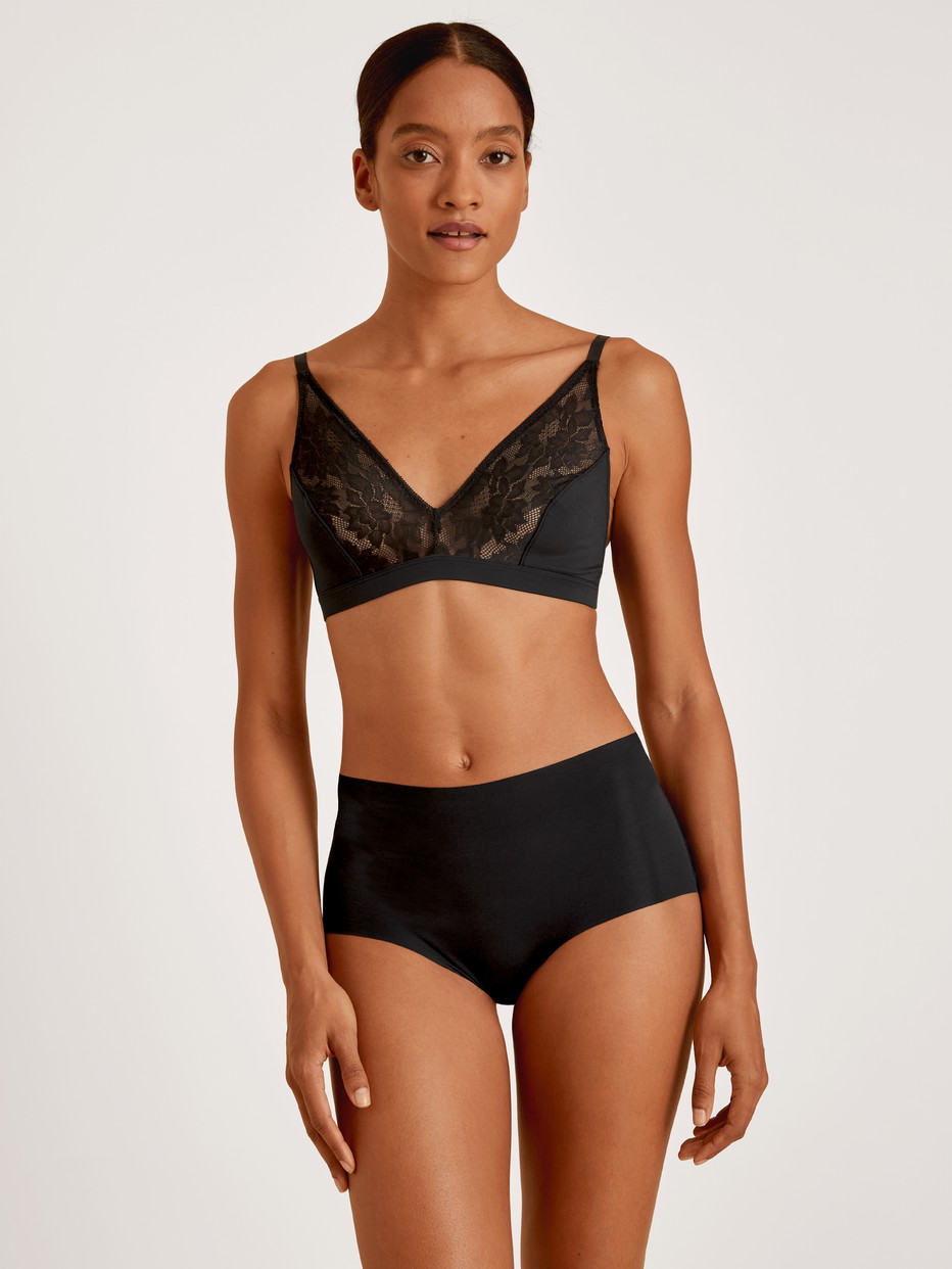 Damen-Model trägt Midislip aus Modal in Schwarz, Spitze aus Serie Natural Skin Lace von CALIDA, Vorderansicht, Outfit
