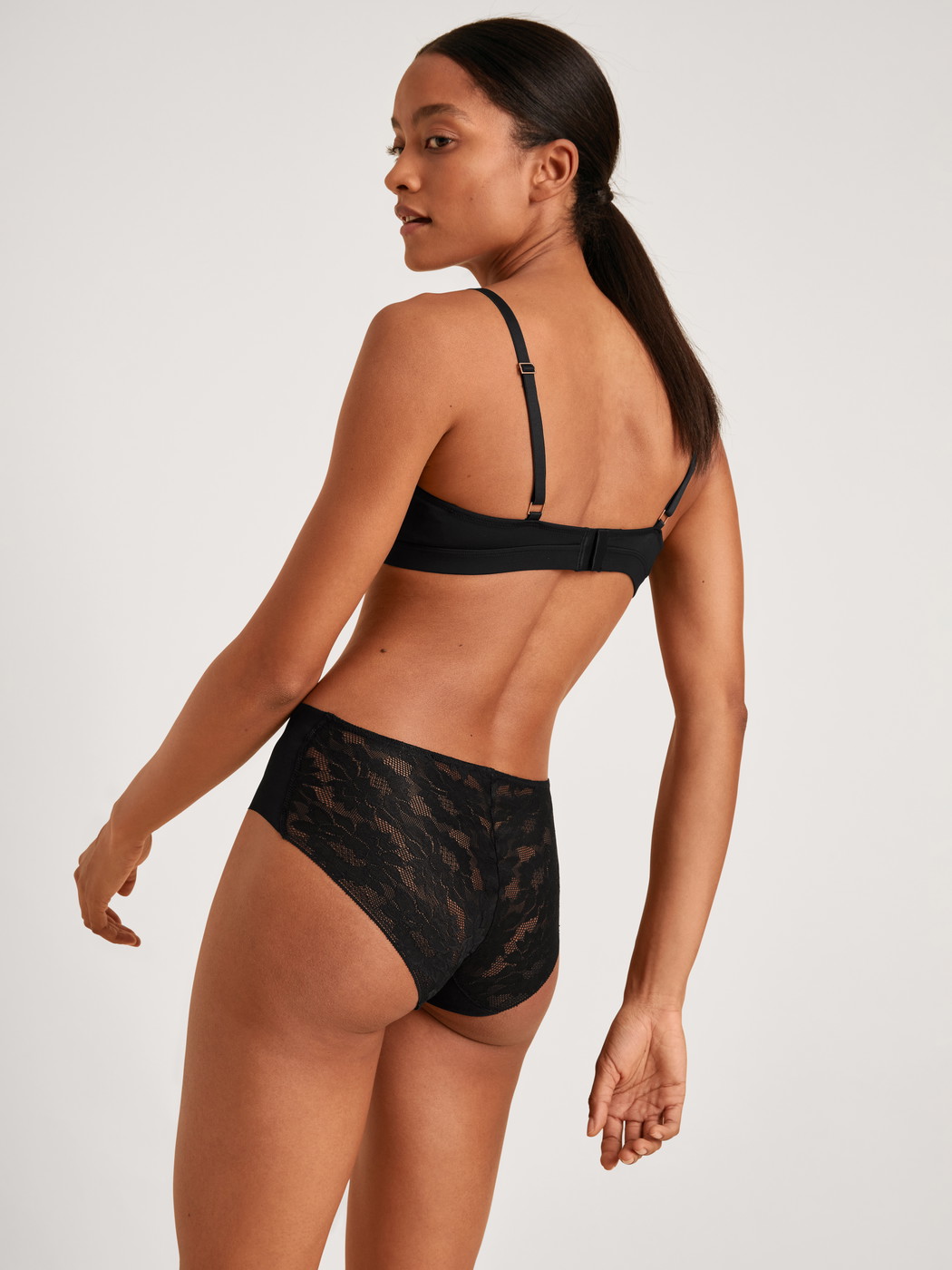 Damen-Model trägt Midislip aus Modal in Schwarz, Spitze aus Serie Natural Skin Lace von CALIDA, Outfit