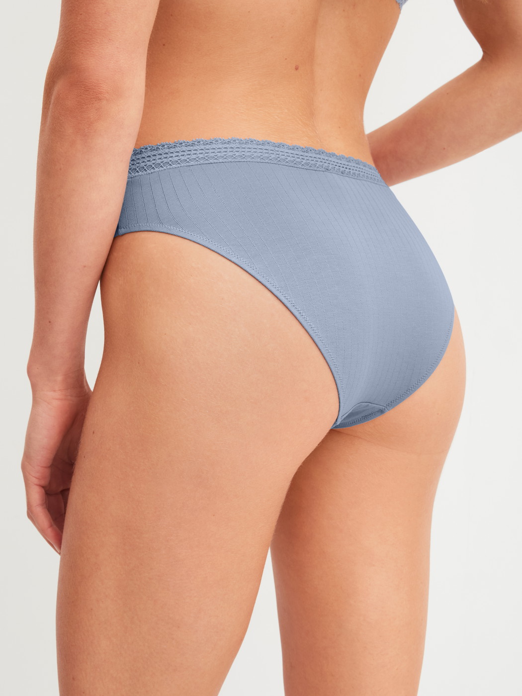 Women model is wearing Brazilian Brief made of Modal in Blue, Lace from the Etude Ajours series by CALIDA, Back view