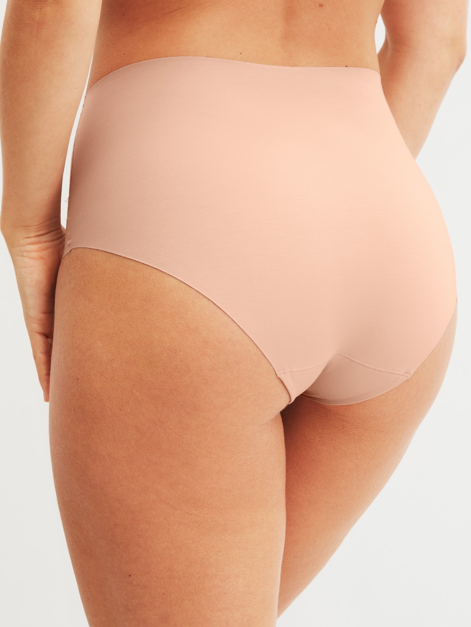 Damen-Model trägt Seamless High-Waist Slip aus Modal in Rosa, Einfarbig aus Serie Natural Skin von CALIDA, Rückansicht