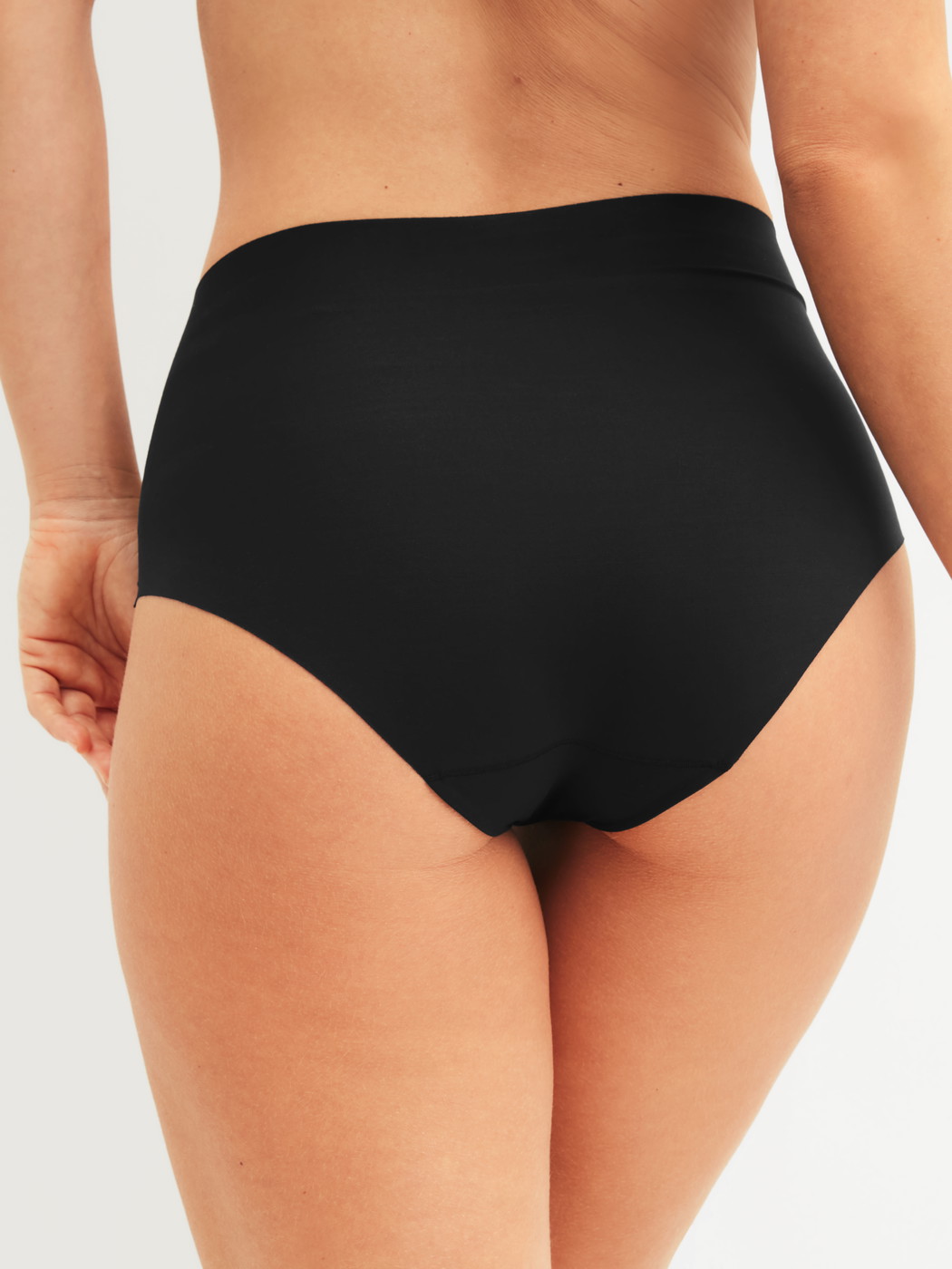 Le mannequin Femme porte le/la Slip taille haute sans couture en Modal de couleur Noir, Unicolore, de la série Natural Skin de CALIDA, Vue arrière