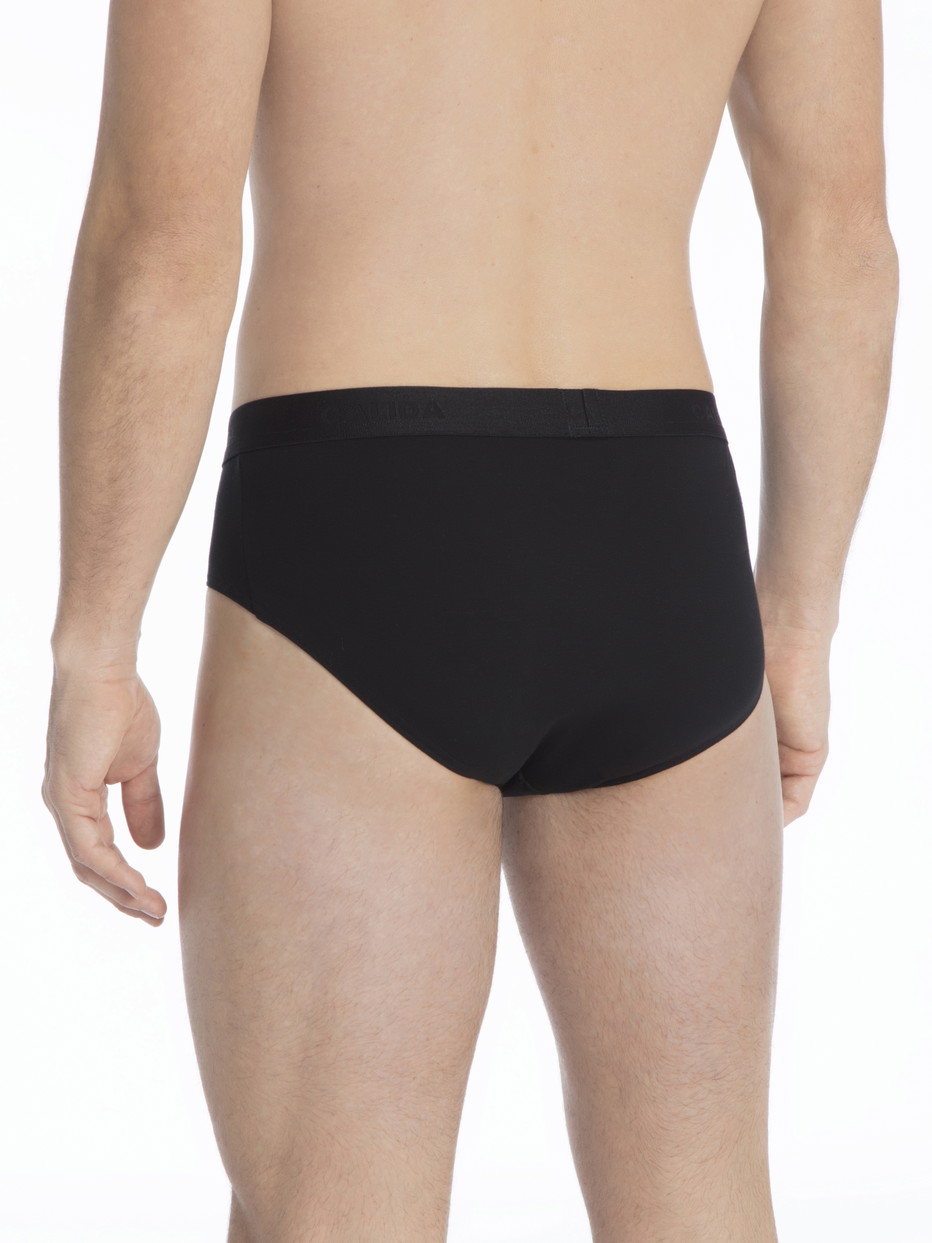 Herren-Model trägt Slip, 3er-Pack aus Baumwolle in Schwarz, Einfarbig aus Serie Natural Benefit von CALIDA, Rückansicht