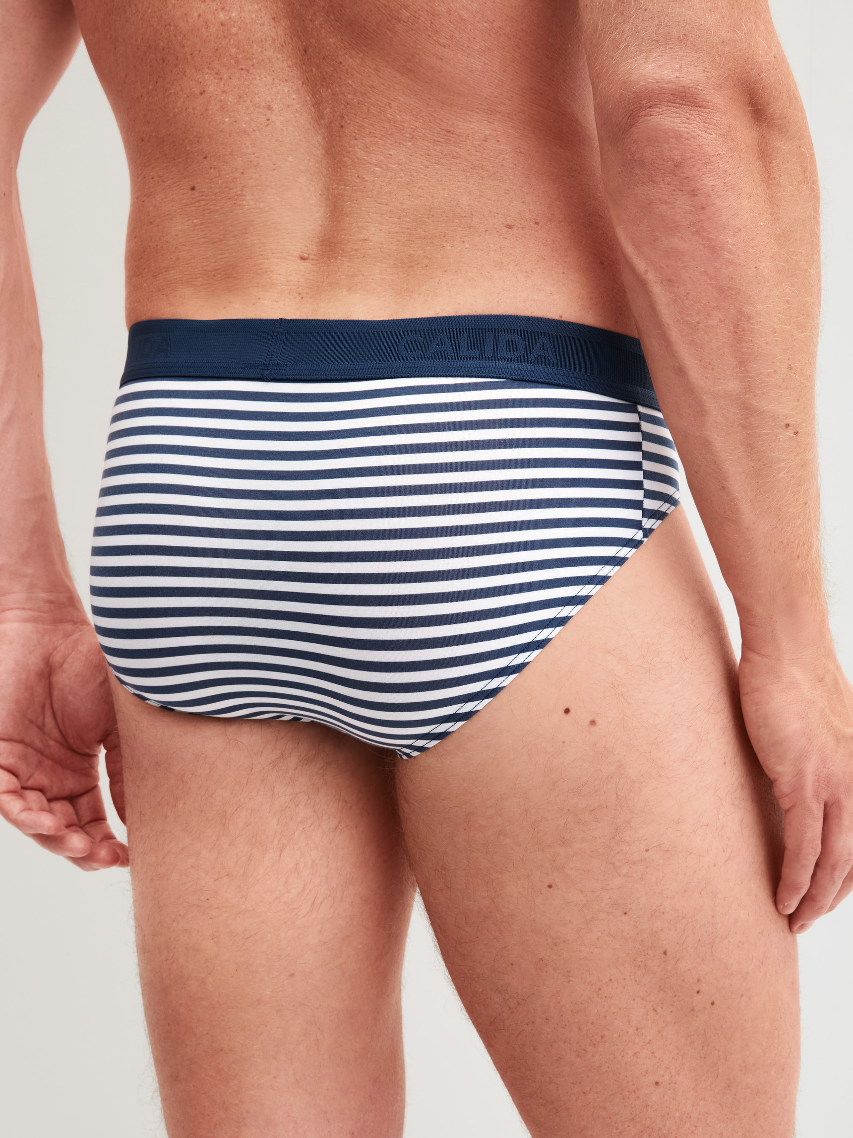 Men model is wearing Brief made of Cotton in Blue, Striped from the Grafic Cotton series by CALIDA, Back view